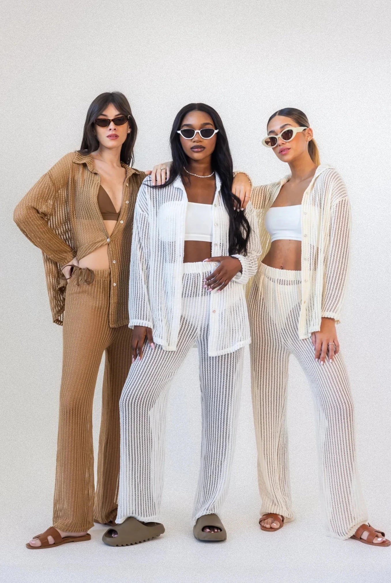 שלוש נשים עם משקפי שמש לובשות חליפות קיץ רשת טרנדיות בצבעים ניוד ולבן
