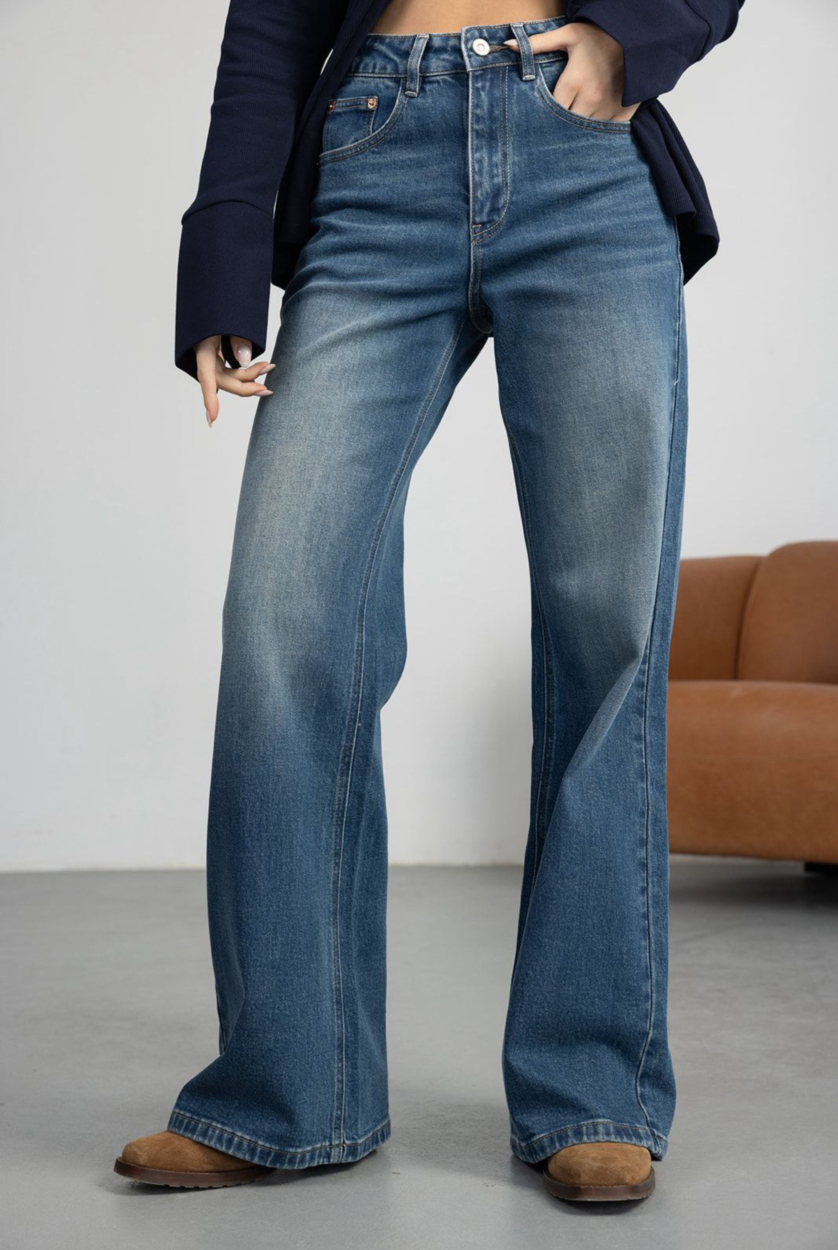 דוגמנית לובשת מכנס ג'ינס בגזרה רחבה לנשים עם חולצת טי צהובה ונעלי סניקרס ורודות, אופנת קיץ צעירה