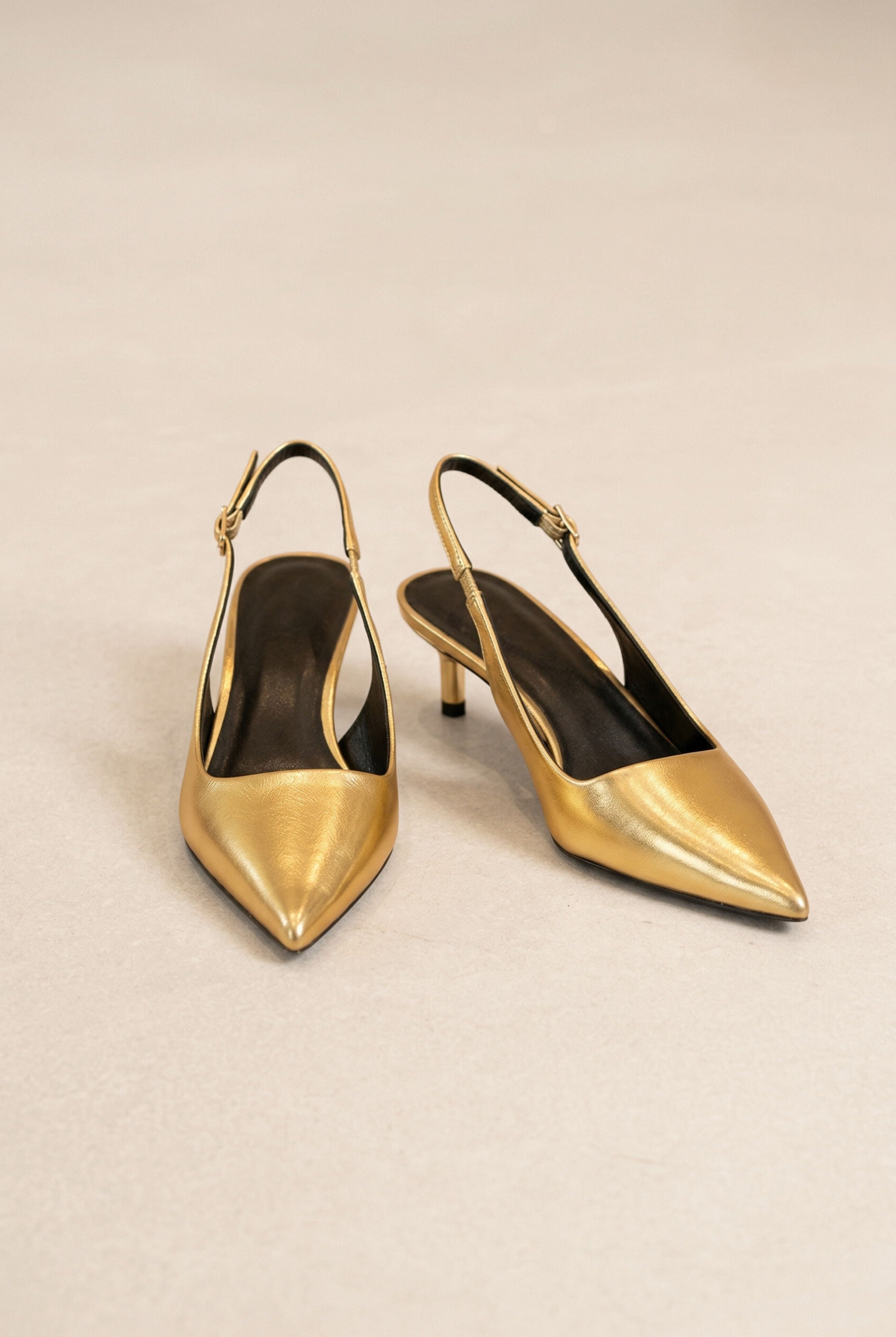 אישה יושבת עם מגפיים גבוהים מעור, גרביון חום וז'קט פרווה, לוק אופנתי לנשים