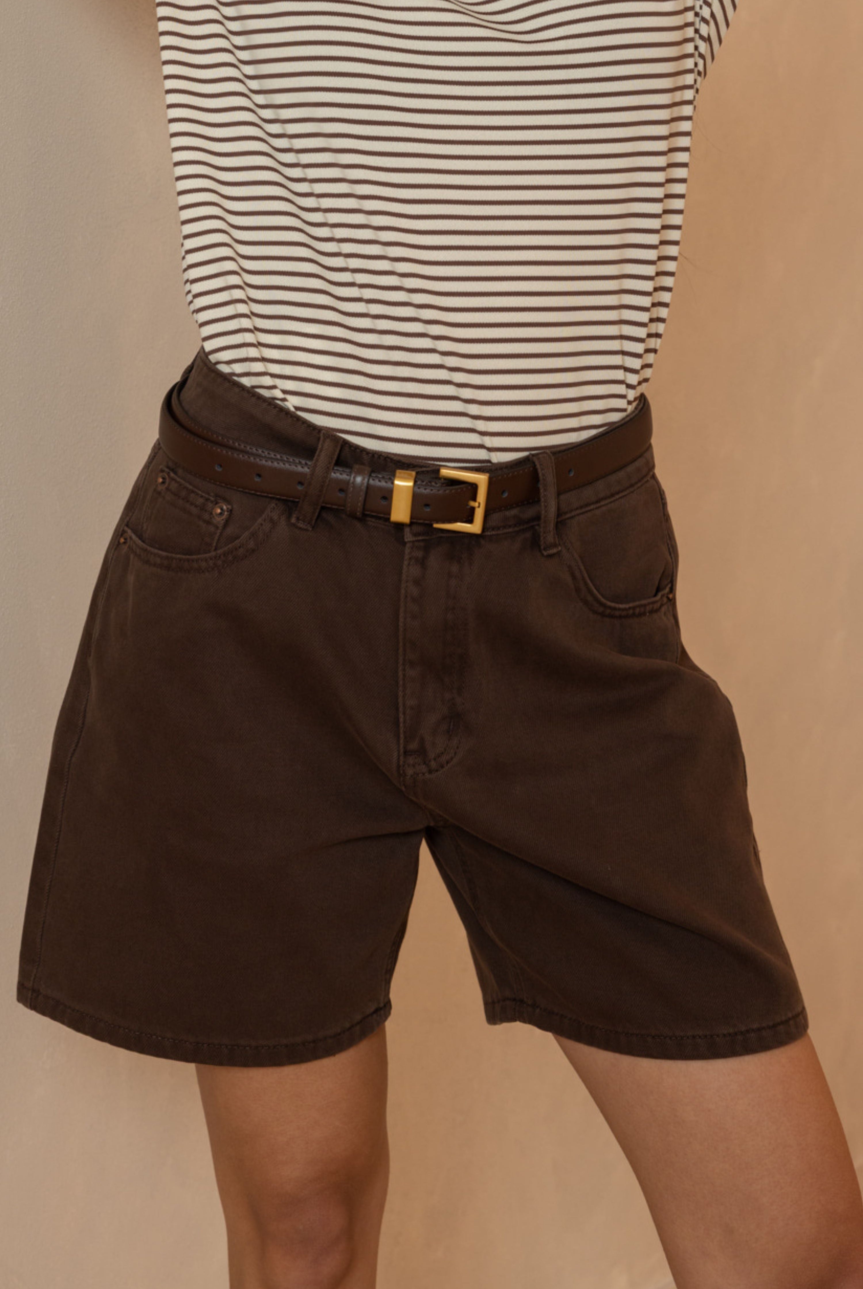 דוגמנית עם חולצה לבנה רחבה, חולצת פלנל משובצת מתחת, מכנסי ג'ינס רחבים ונעלי פלטפורמה