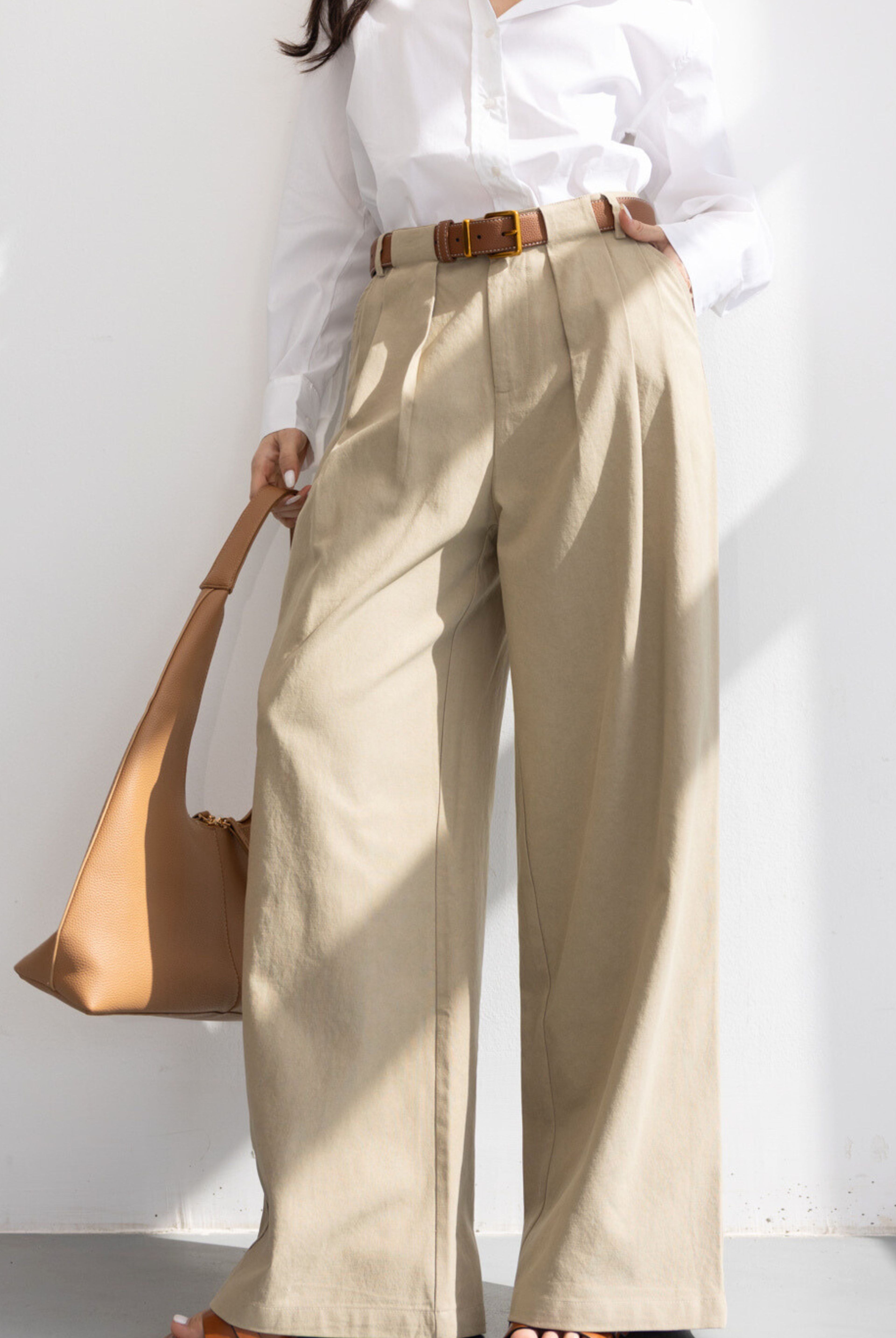 דוגמנית עם חולצה לבנה רחבה, חולצת פלנל משובצת מתחת, מכנסי ג'ינס רחבים ונעלי פלטפורמה