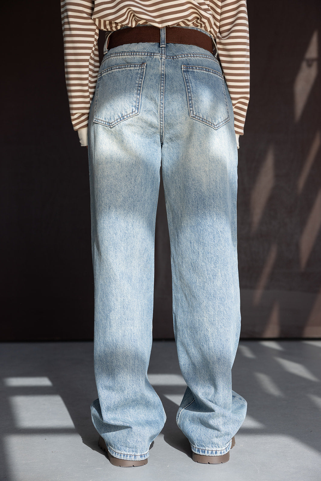 ג׳ינס בגזרה רחבה לנשים, גוון תכלת, בשילוב חגורה, חולצת פסים חומה ארוכה