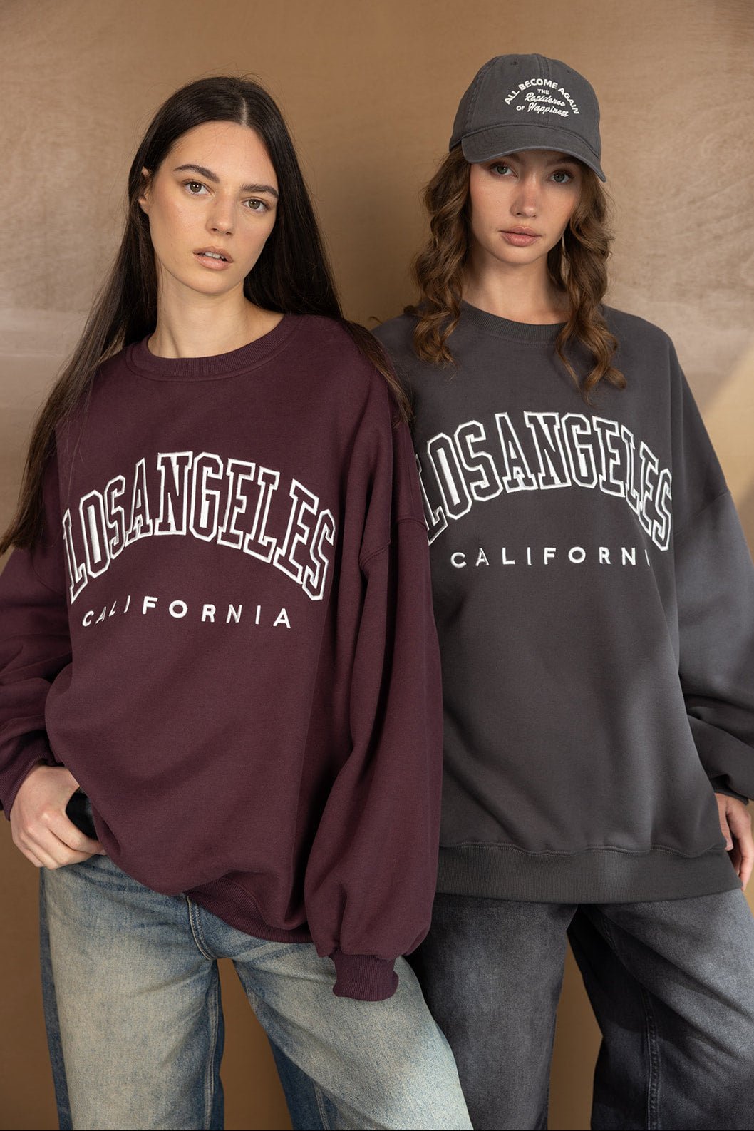 שתי נשים לובשות סווטשירט אופנתי עם הדפס לוס אנג'לס קליפורניה, בגדי קז'ואל לנערות