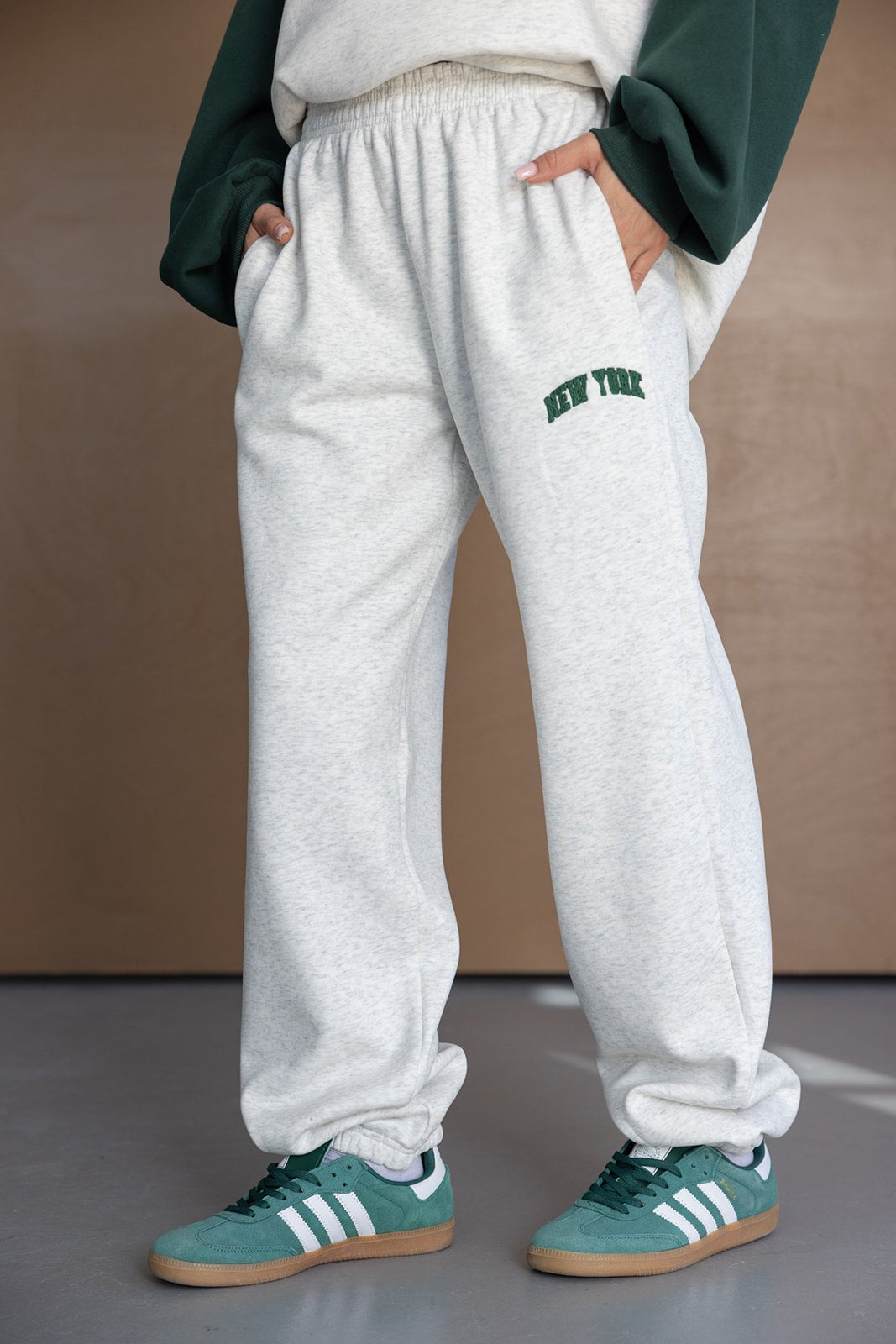מכנסי טרנינג אפור עם כיתוב ניו יורק, נעלי ספורט ירוקות, סטייל אופנתי לנשים