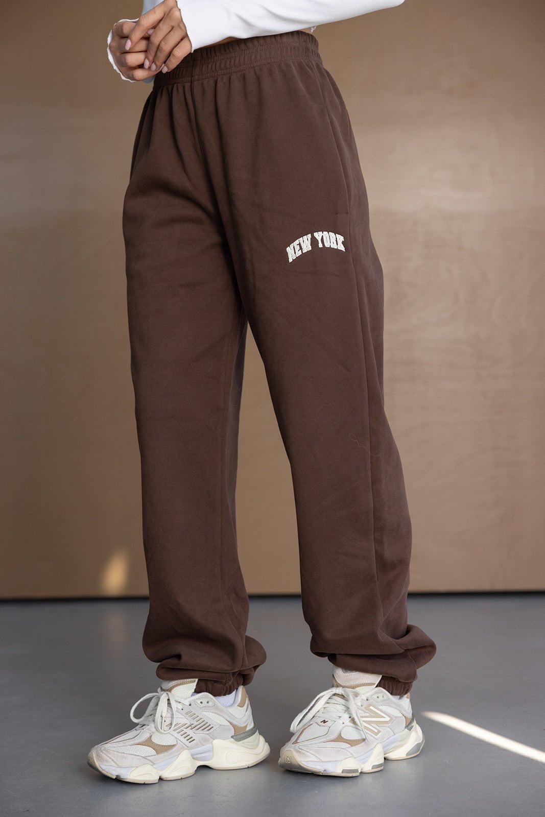 מכנסי טרנינג חומים לנשים עם כיתוב 'NEW YORK', גזרה משוחררת ונעלי סניקרס לבנות