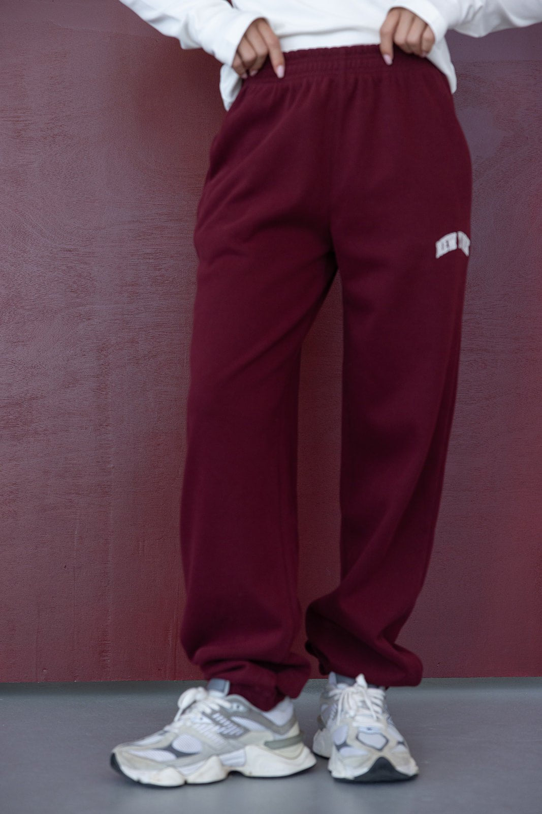 מכנסי טרנינג בורדו נשים עם דיטייל לוגו, נעלי סניקרס אופנתיות, לוק יומיומי אופנתי