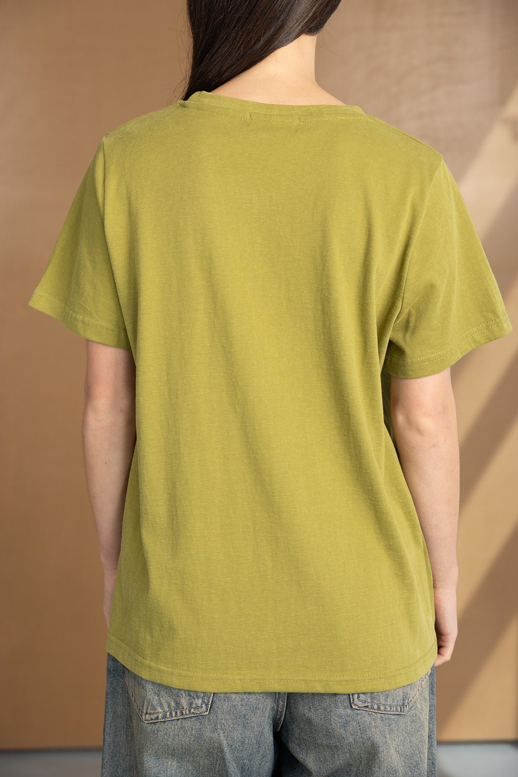 חולצת טי שירט ירוקה לנשים, מבט מאחור, סטייל קז'ואל עם מכנסי ג'ינס