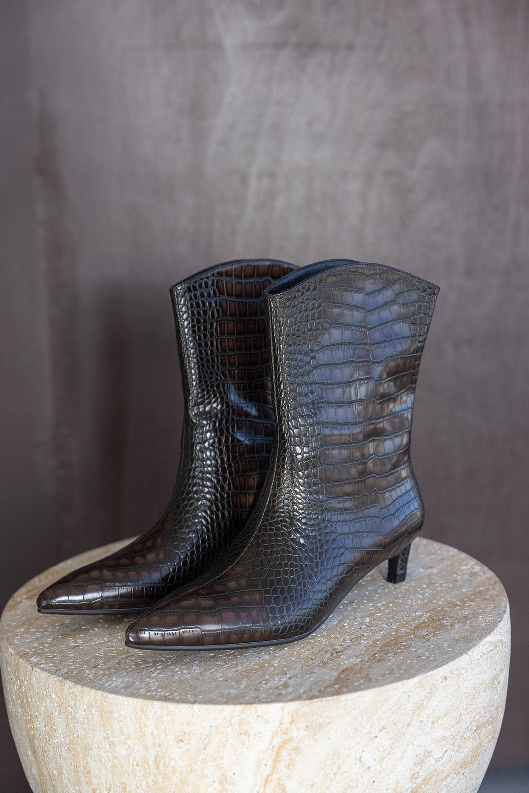 מגפי נשים שחורים עם טקסטורת עור תנין עקב נמוך אופנתיים על שולחן עגול