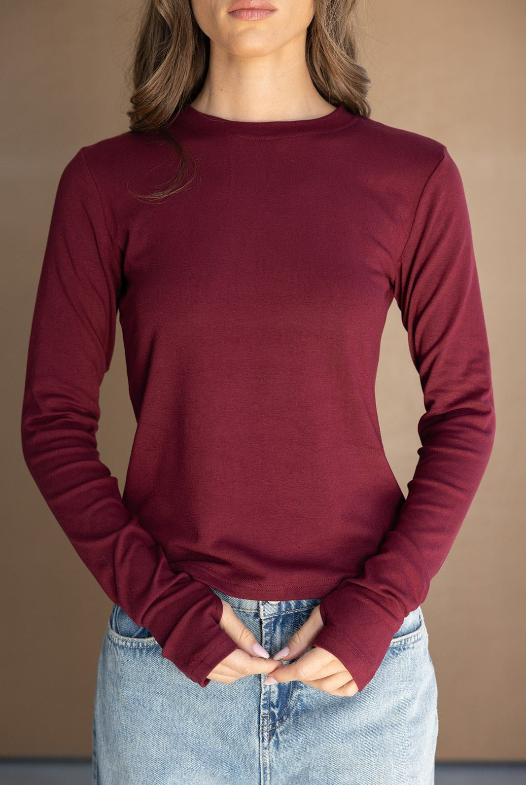 חולצת נשים בורדו שרוול ארוך מבד חלק עם צווארון עגול, בשילוב ג'ינס בהיר