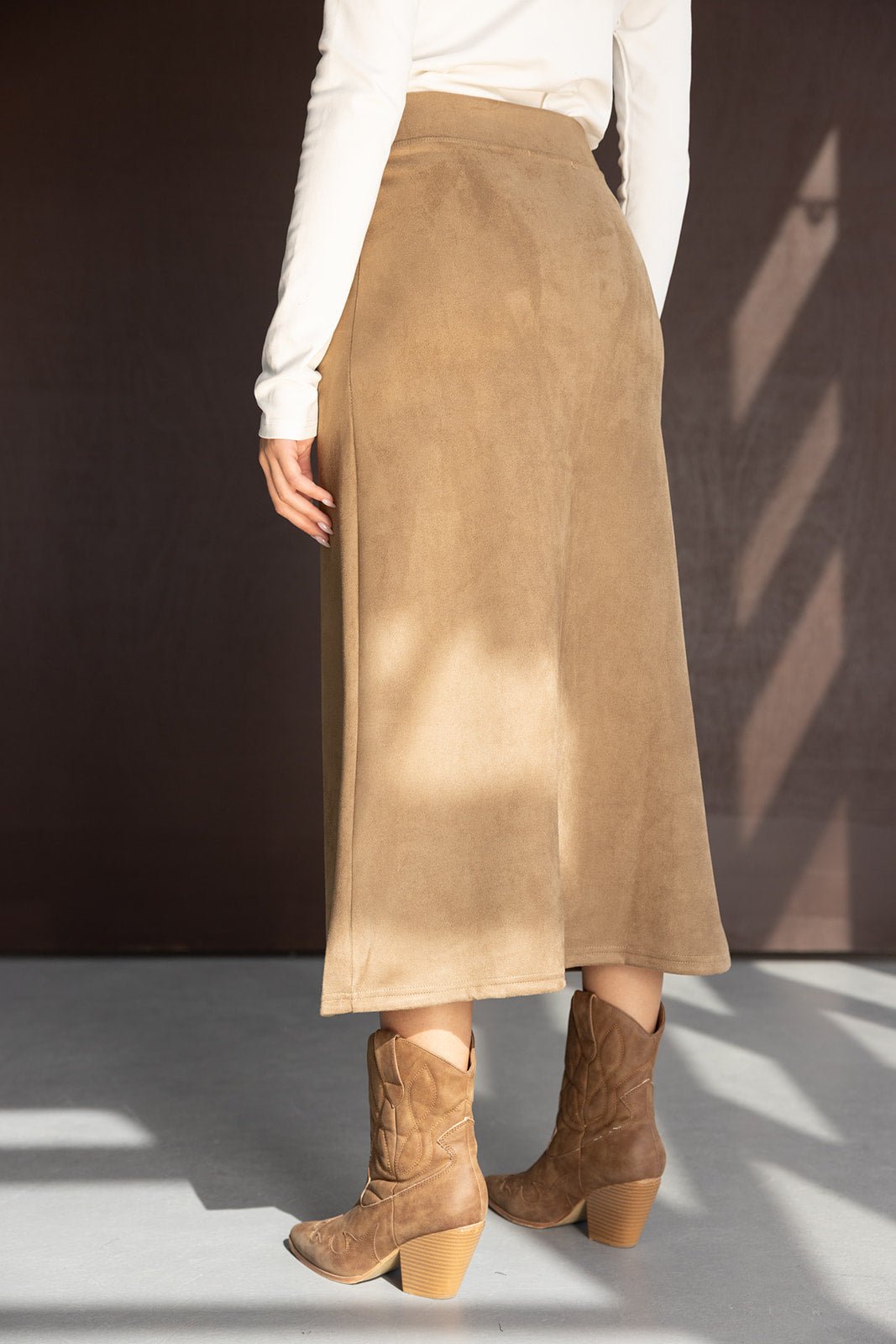 חצאית מידי לנשים בצבע בז', חולצה לבנה ונעלי בוקרים חומות, צילום אופנה בסטודיו