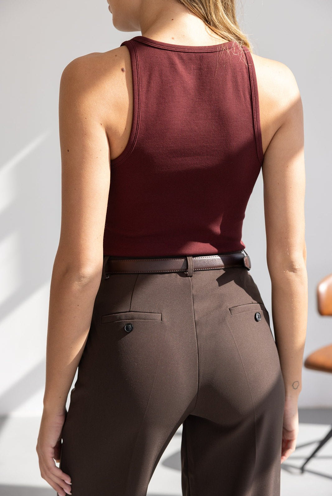 גופיית נשים בורדו ומכנסיים מחויטים חומים, צילום גב, אופנת נשים צעירה