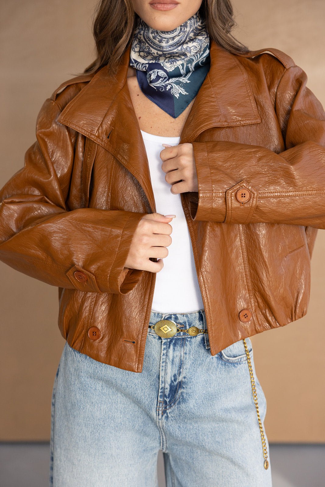 ג׳קט עור חום לנשים, ג׳ינס בהיר, חולצה לבנה וצעיף צוואר אופנתי, מראה טרנדי לנערות