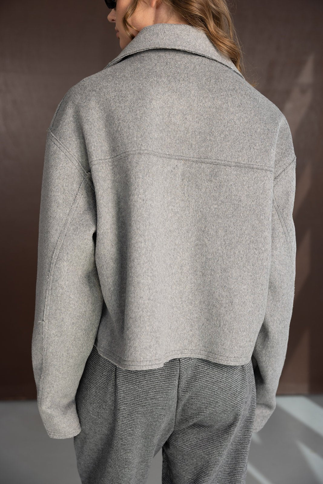 אישה עם ז'קט צמר אפור ומכנסיים אפורים מודרניים, צילום אופנה לנשים