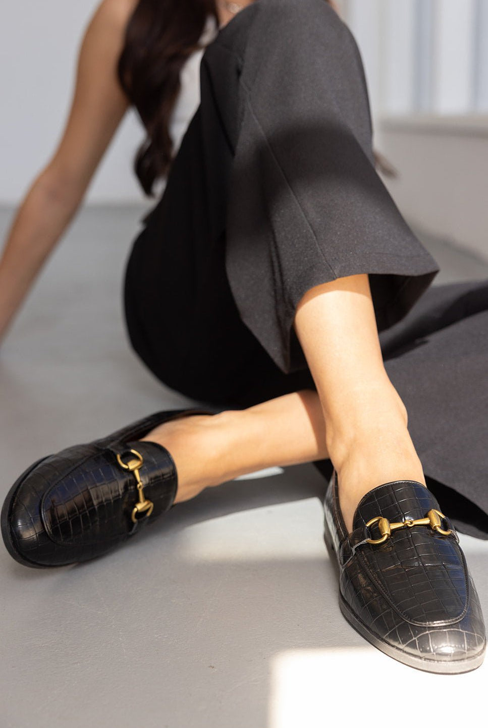 נעליים שטוחות לנשים דמוי עור תנין שחור עם אבזם זהב, משולבות עם מכנסיים שחורים אופנתיים