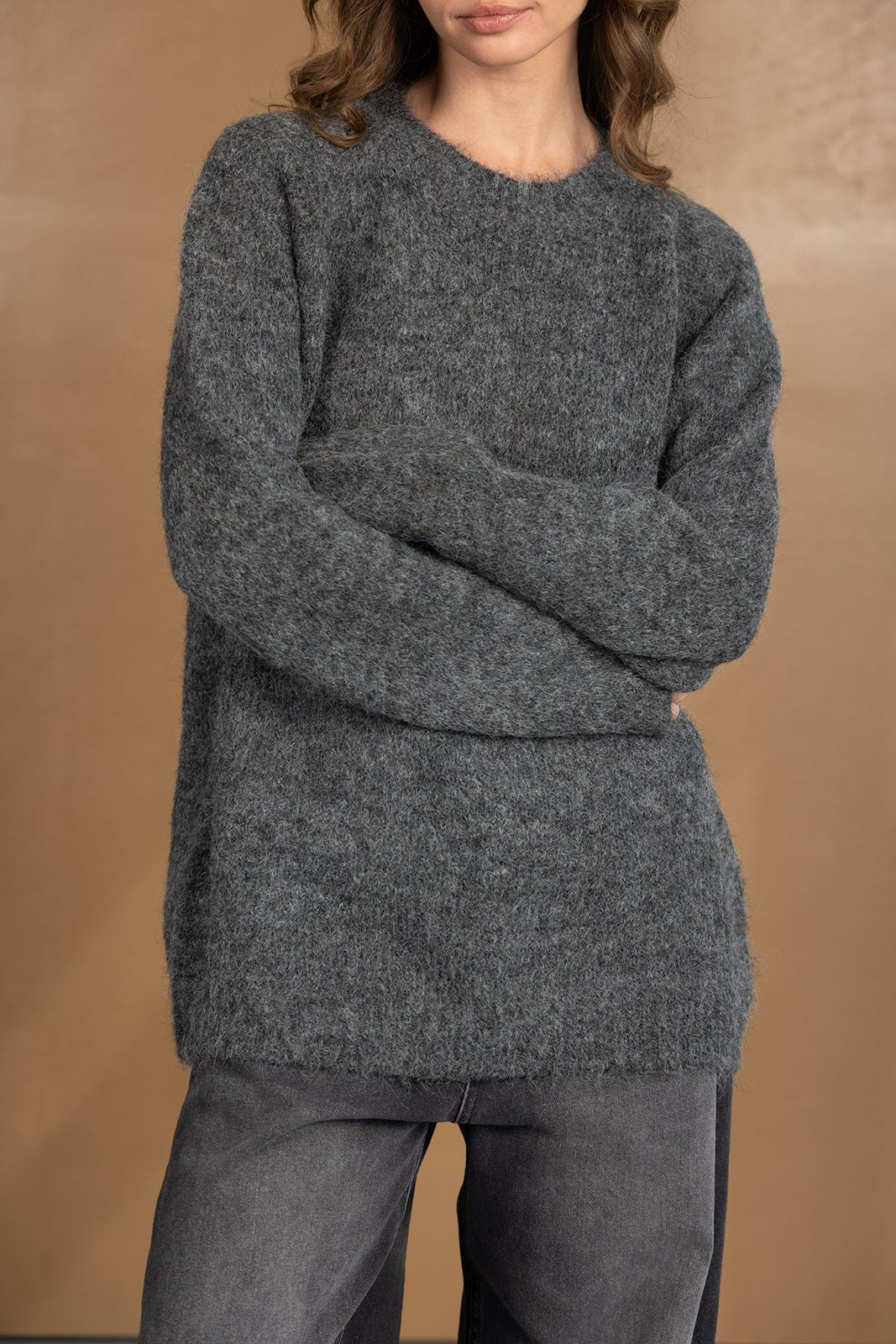 דוגמנית לובשת סוודר אפור לנשים עם מרקם רך ומכנסיים בגוון כהה, אופנת חורף קז'ואל