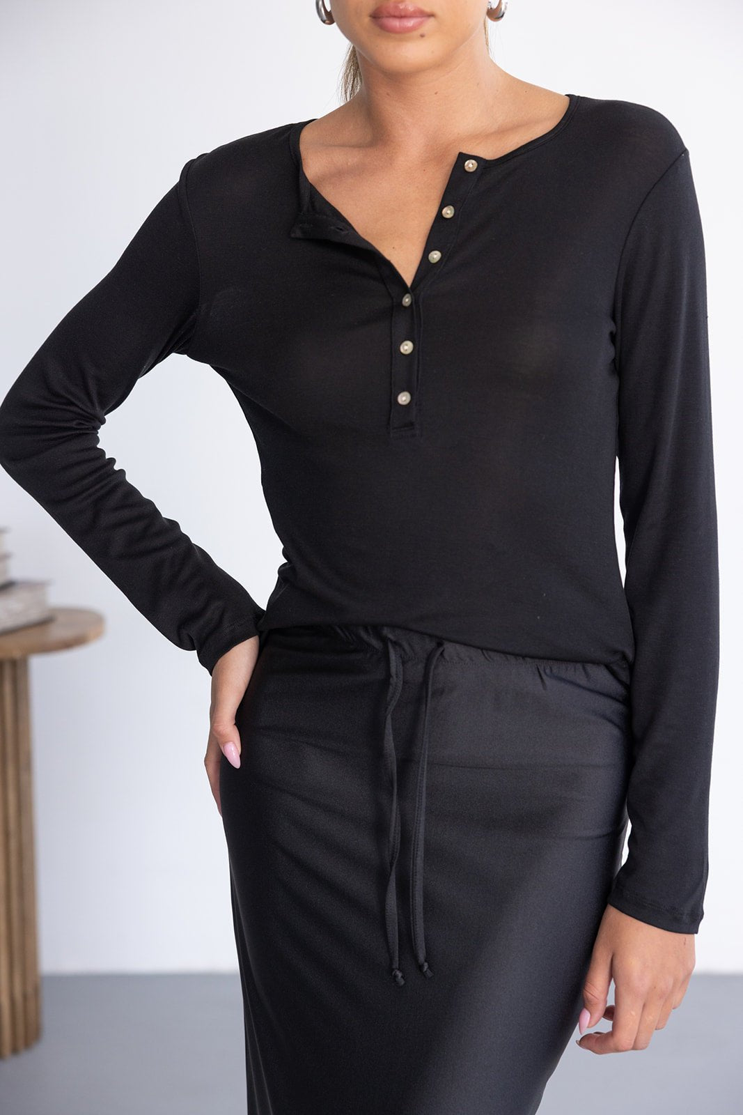 דוגמנית לובשת חולצה שחורה כפתורים ומכנס שחור, אופנה לנשים צעירות