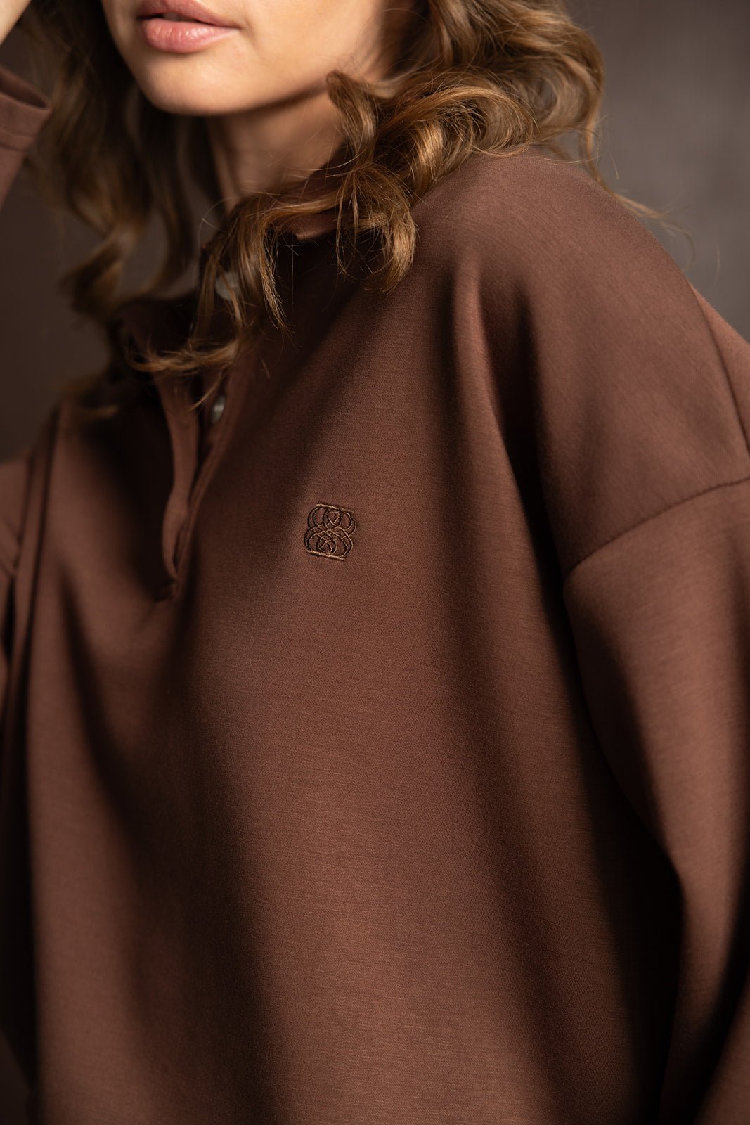 אישה עם חולצת קפוצ׳ון חומה לנשים, בד רך וגזרה רחבה, אופנת נשים חורף