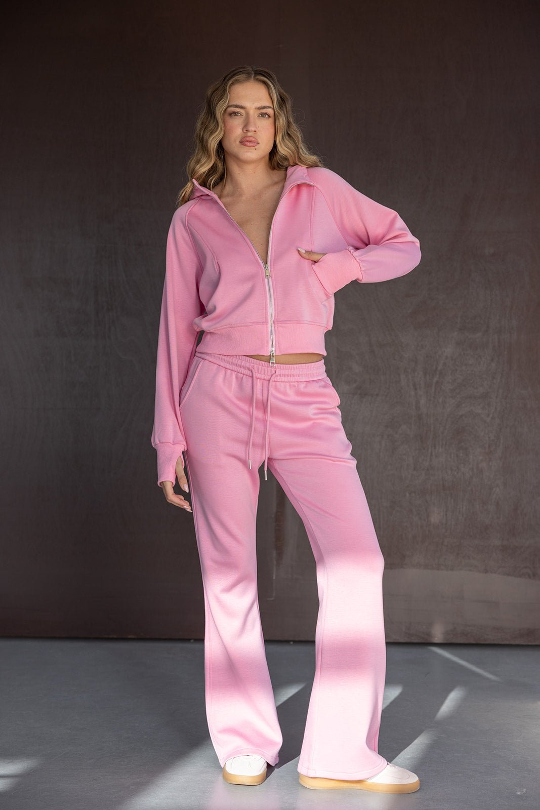 דוגמנית בלבוש ספורטיבי ורוד, סט טרנינג לנשים עם רוכסן ומכנסיים מתרחבים, אופנת קז'ואל לנשים