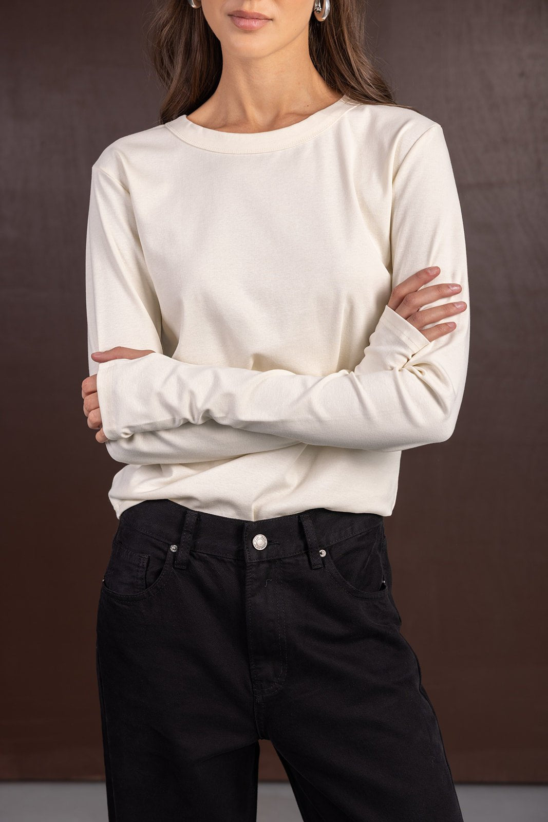 אישה עם חולצת בייסיק לבנה ארוכה ומכנסי ג'ינס שחורים, אופנת נשים קז'ואל