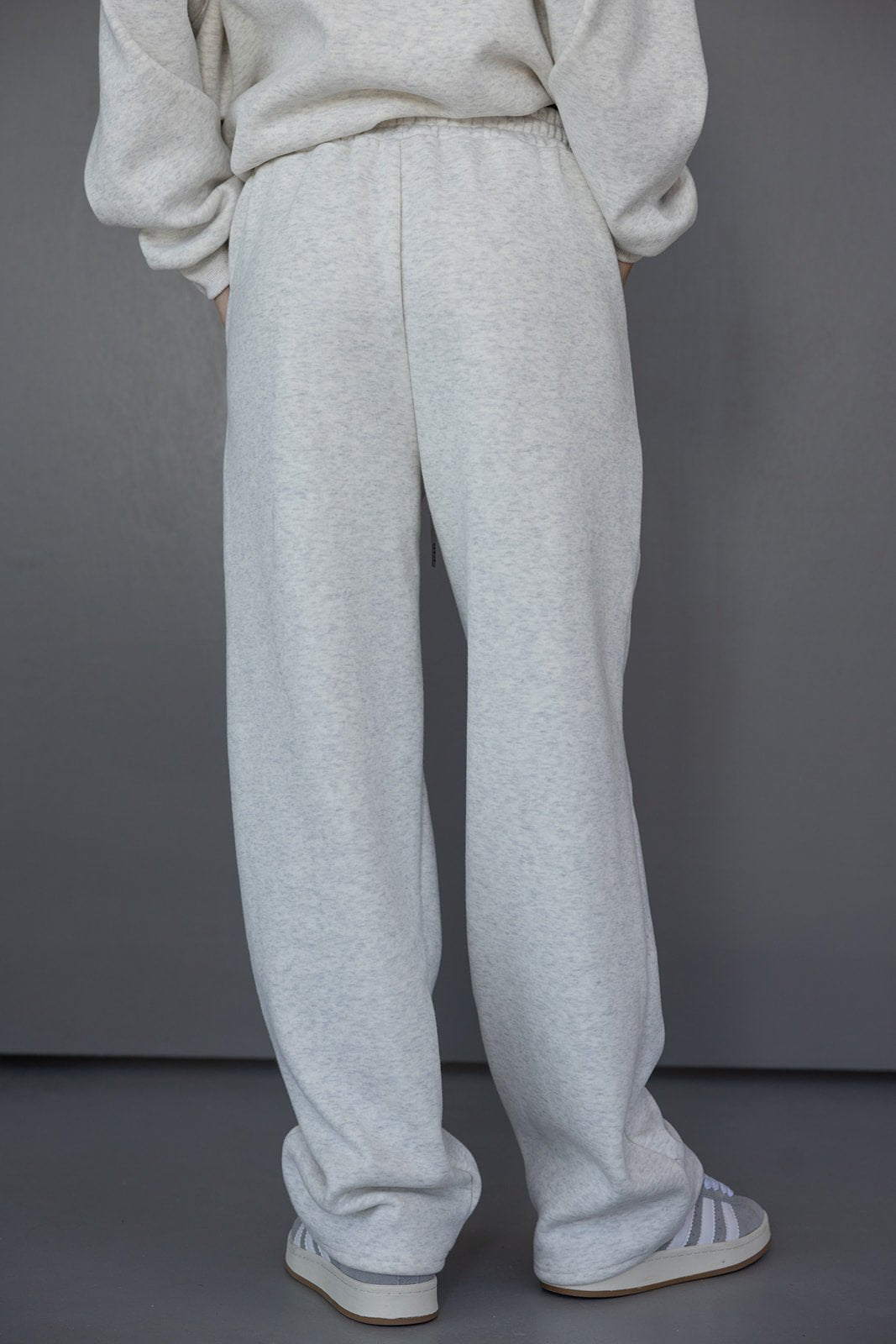 טרנינג נשים אפור בהיר במראה רחב ונוח, עם גומי במותן ונעלי ספורט אופנתיות