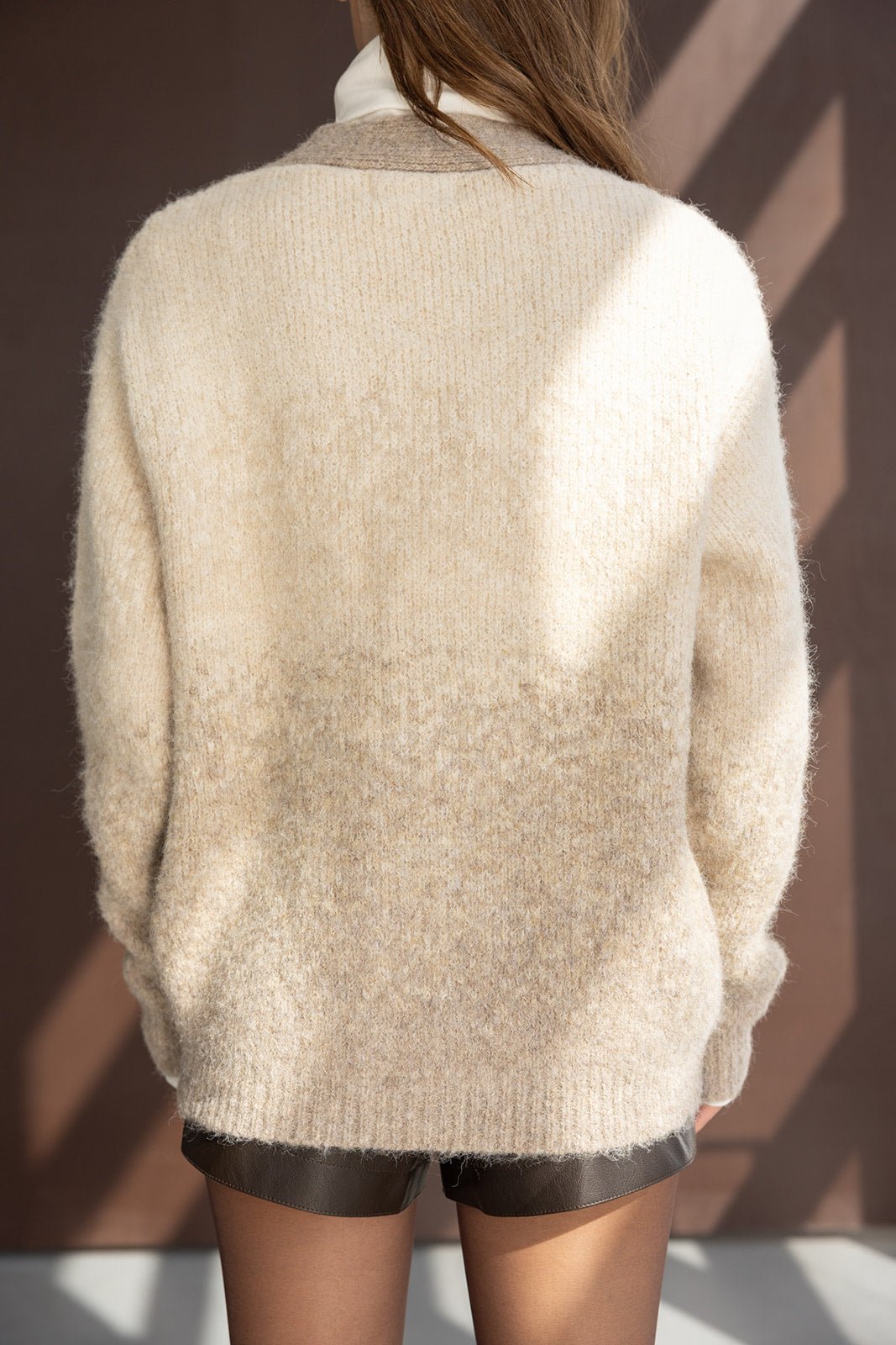 סוודר נשים בצבע בז' מרקם צמר, מצולם מאחור, על דוגמנית עם שיער פתוח