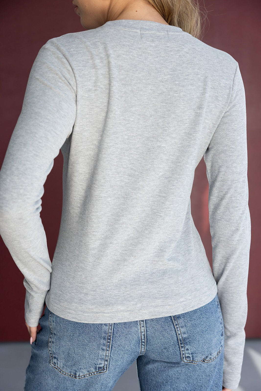 חולצת שרוול ארוך אפורה לנשים עם ג'ינס כחול, צילום מהגב, אופנת קז'ואל לנערות