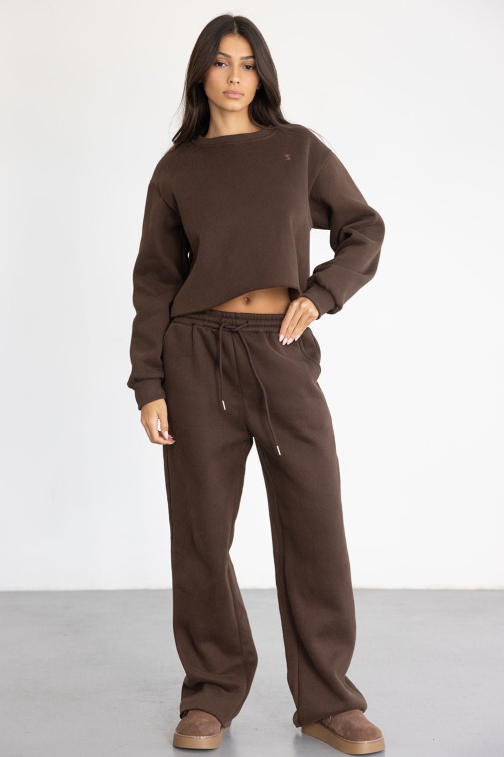 דוגמנית לובשת סט טרנינג חום לנשים, חולצה ארוכה ומכנסיים בגזרה רחבה, אופנה נוחה לעונה