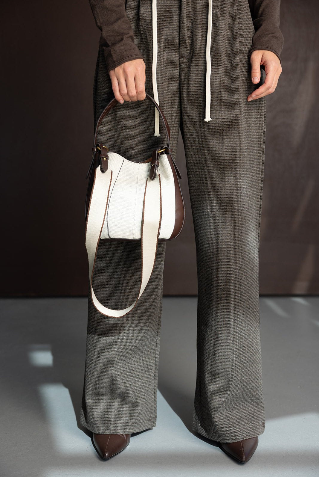 מכנסיים רחבים לנשים בצבע חום משבצות, נעליים מחודדות ותיק צד בד חום לבן, אופנת נשים עדכנית