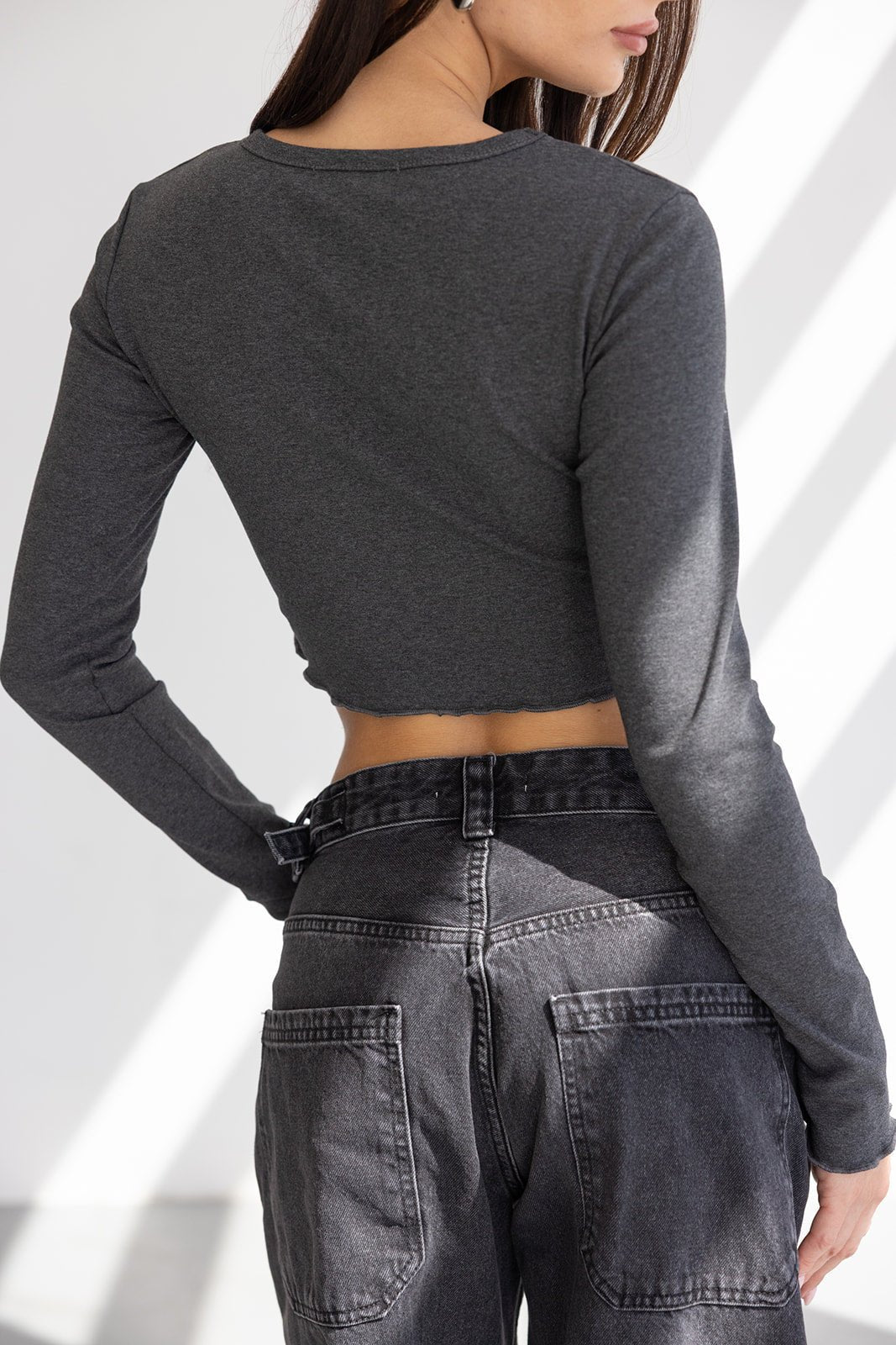 חולצת קרופ ארוכה בצבע אפור כהה עם שרוולים ארוכים, בשילוב ג'ינס שחור בגזרה גבוהה לנשים