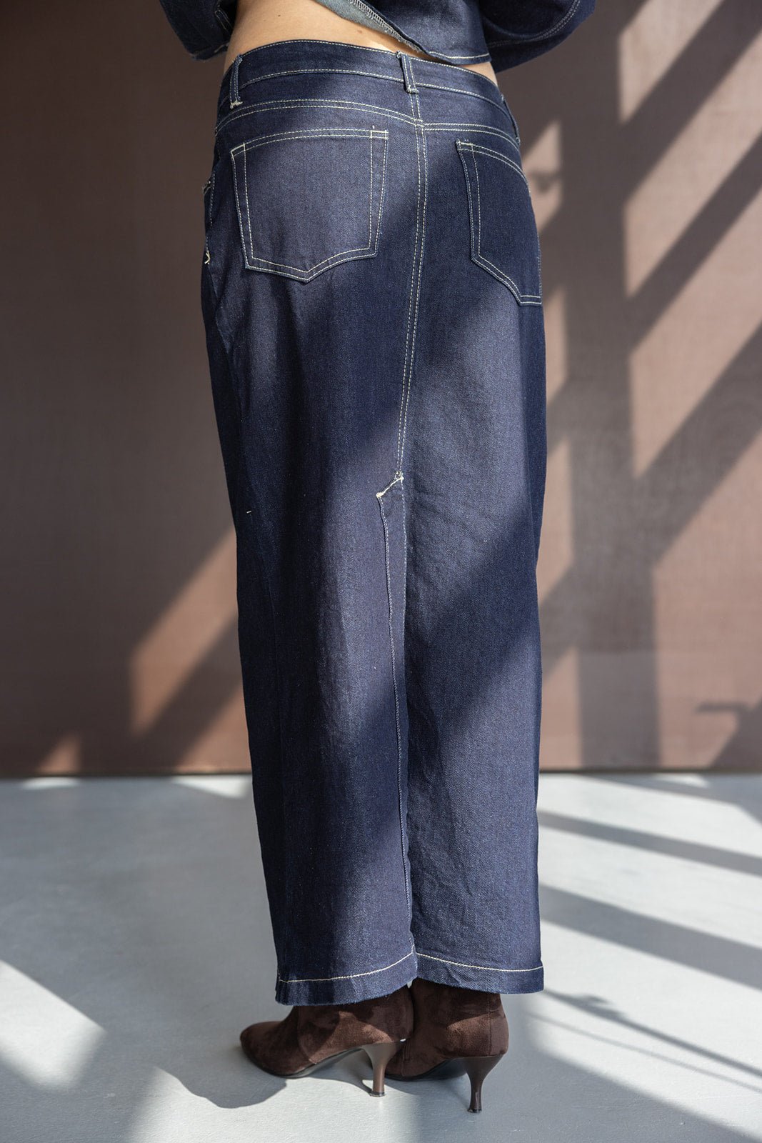 חצאית ג'ינס ארוכה לנשים בגזרה ישרה עם תפרים בולטים, צולם באור טבעי