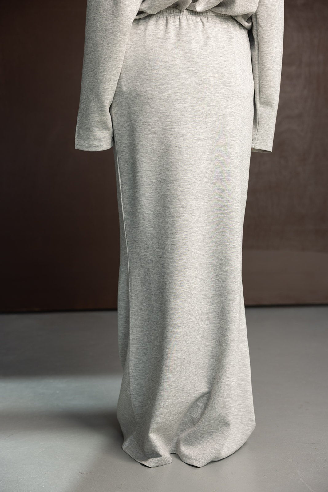 חצאית מקסי אפורה לנשים בגזרה ישרה מבד נוח, מצולמת על רקע חום