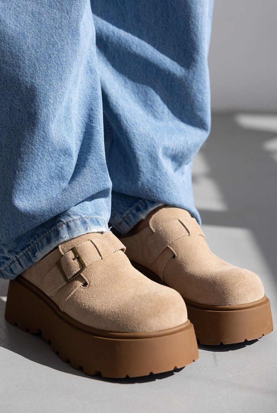 נעלי מוקסין נשים בז׳ עם סוליה עבה ובקלס סגור, בשילוב ג׳ינס כחול רחב