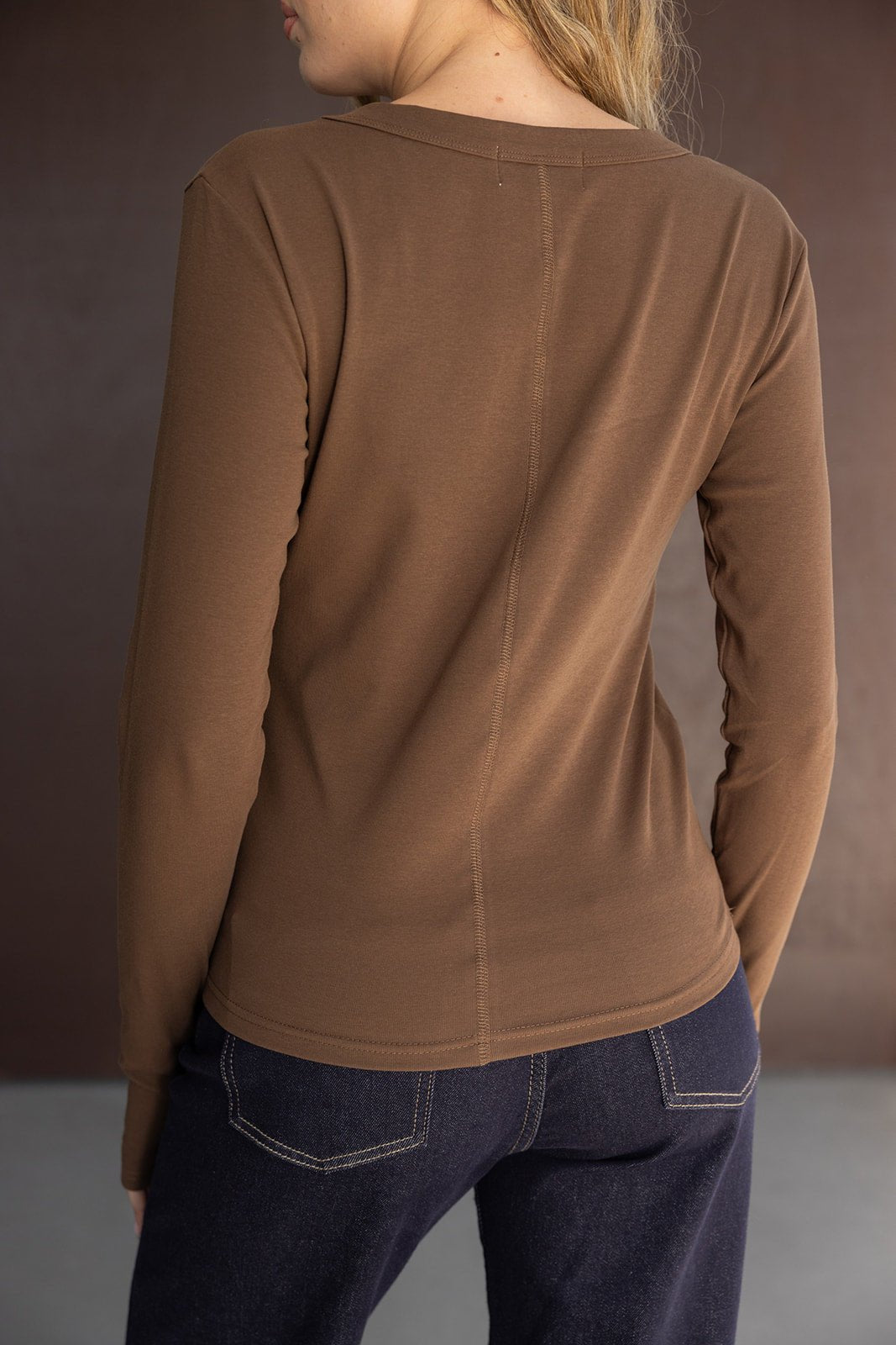 חולצת נשים ארוכה בצבע חום עם ג'ינס כחול כהה, מבט מאחור, אופנה לנערות