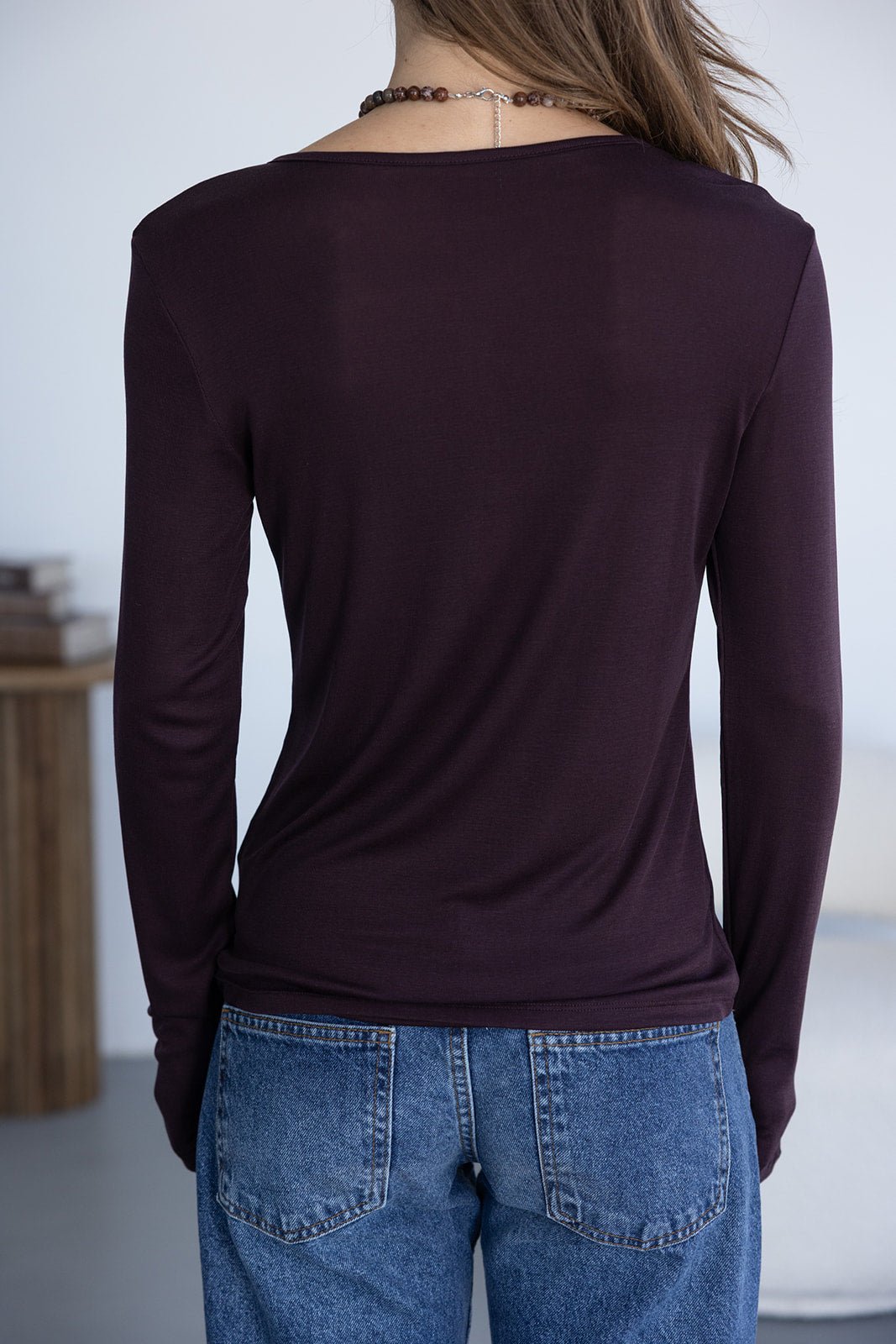 חולצת בייסיק סגולה שרוולים ארוכים וג׳ינס קלאסי לאישה, צילום מאחור, אופנה לנערות