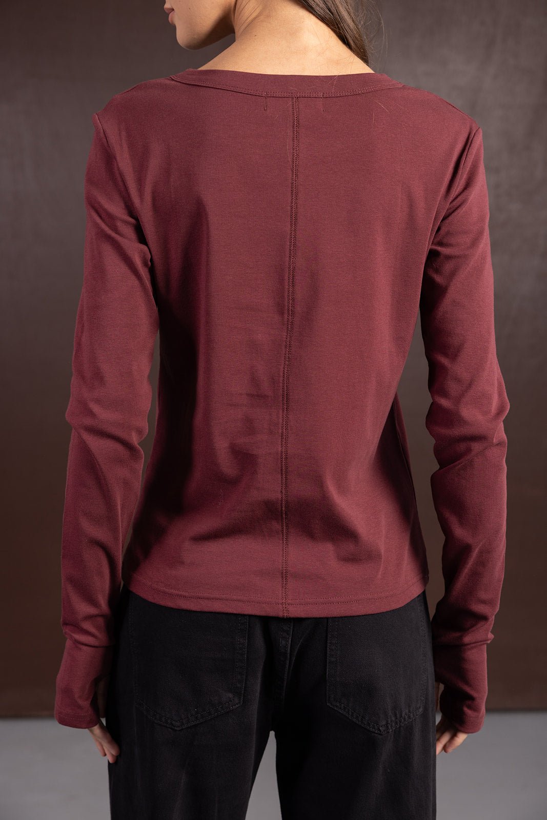 חולצת נשים בורדו ארוכה עם תפר אחורי, לבושה עם מכנסיים שחורים, אופנת קז'ואל חורפית