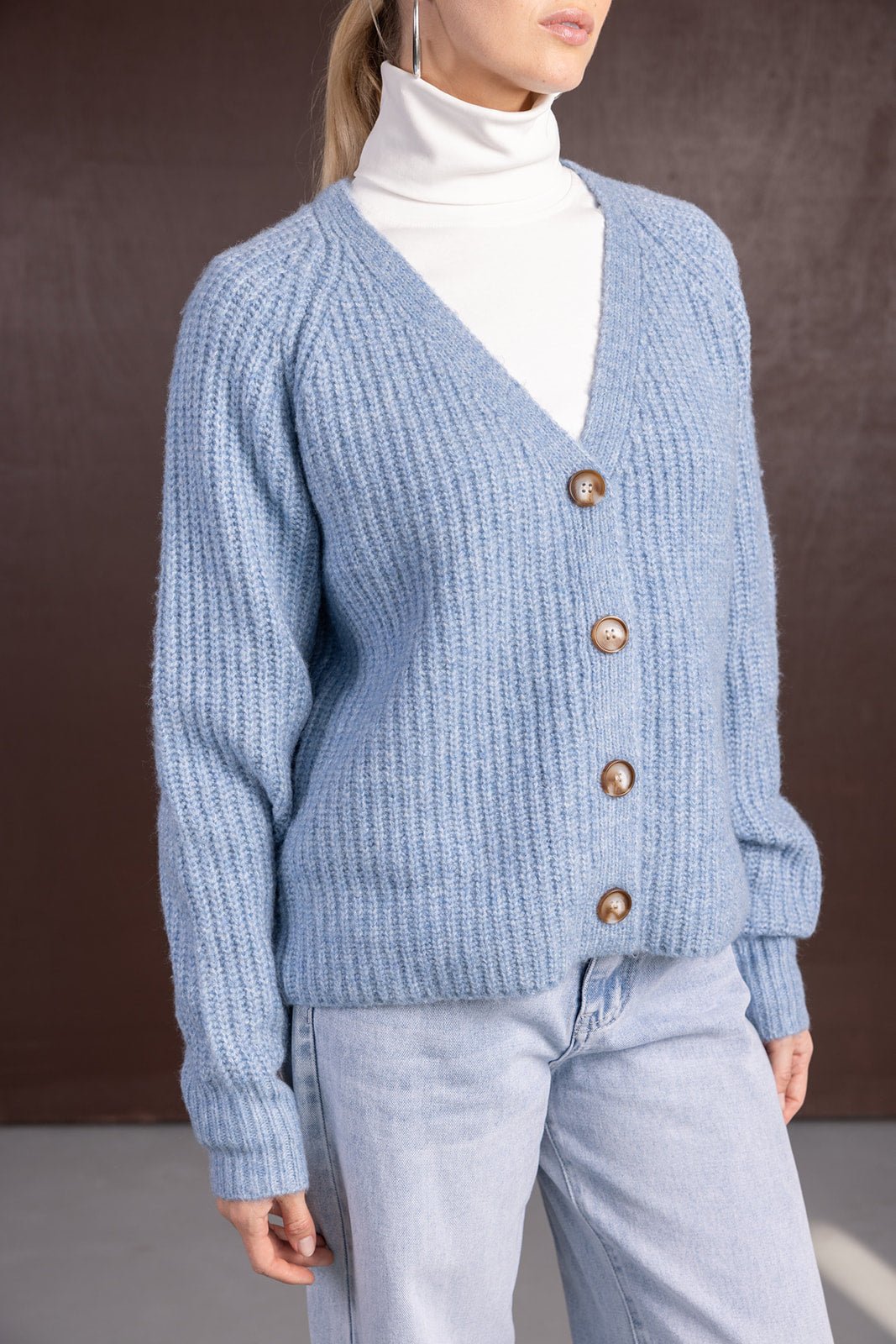 קרדיגן סרוג פתוח לנשים בצבע תכלת עם כפתורים, חולצת גולף לבנה ומכנסי ג'ינס בהירים