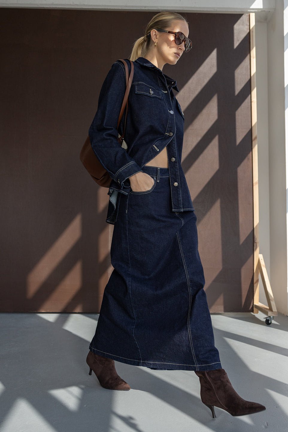 אישה עם ז'קט ג'ינס וחצאית ארוכה, נעלי עקב חומות ומשקפי שמש, לוק אופנתי לנשים