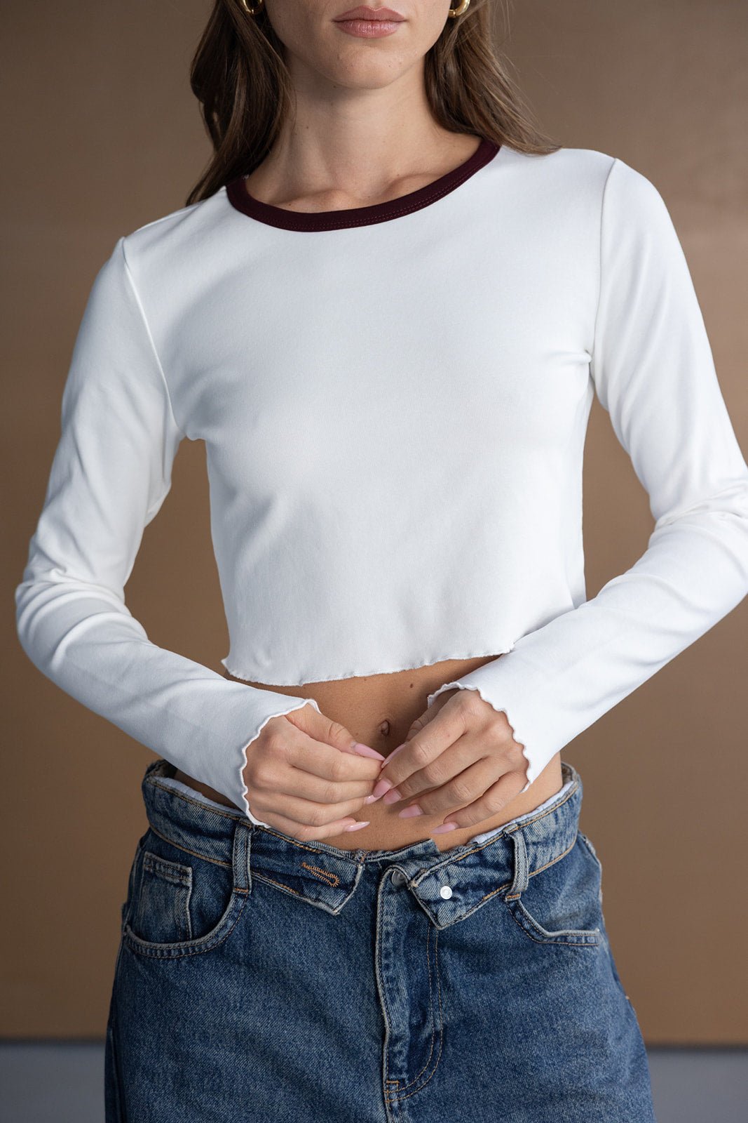 חולצת קרופ לבנה ארוכה עם קצה גלי וצווארון כהה, ג'ינס קז'ואל לנשים