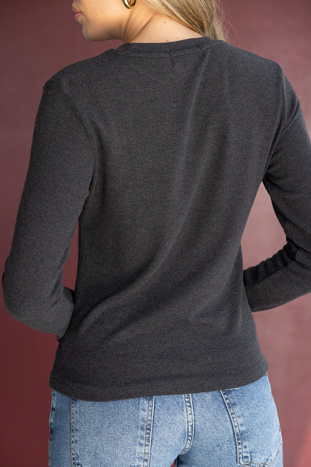 חולצת נשים שרוול ארוך בצבע שחור, בד רך, משולבת עם ג'ינס כחול, מבט מאחור