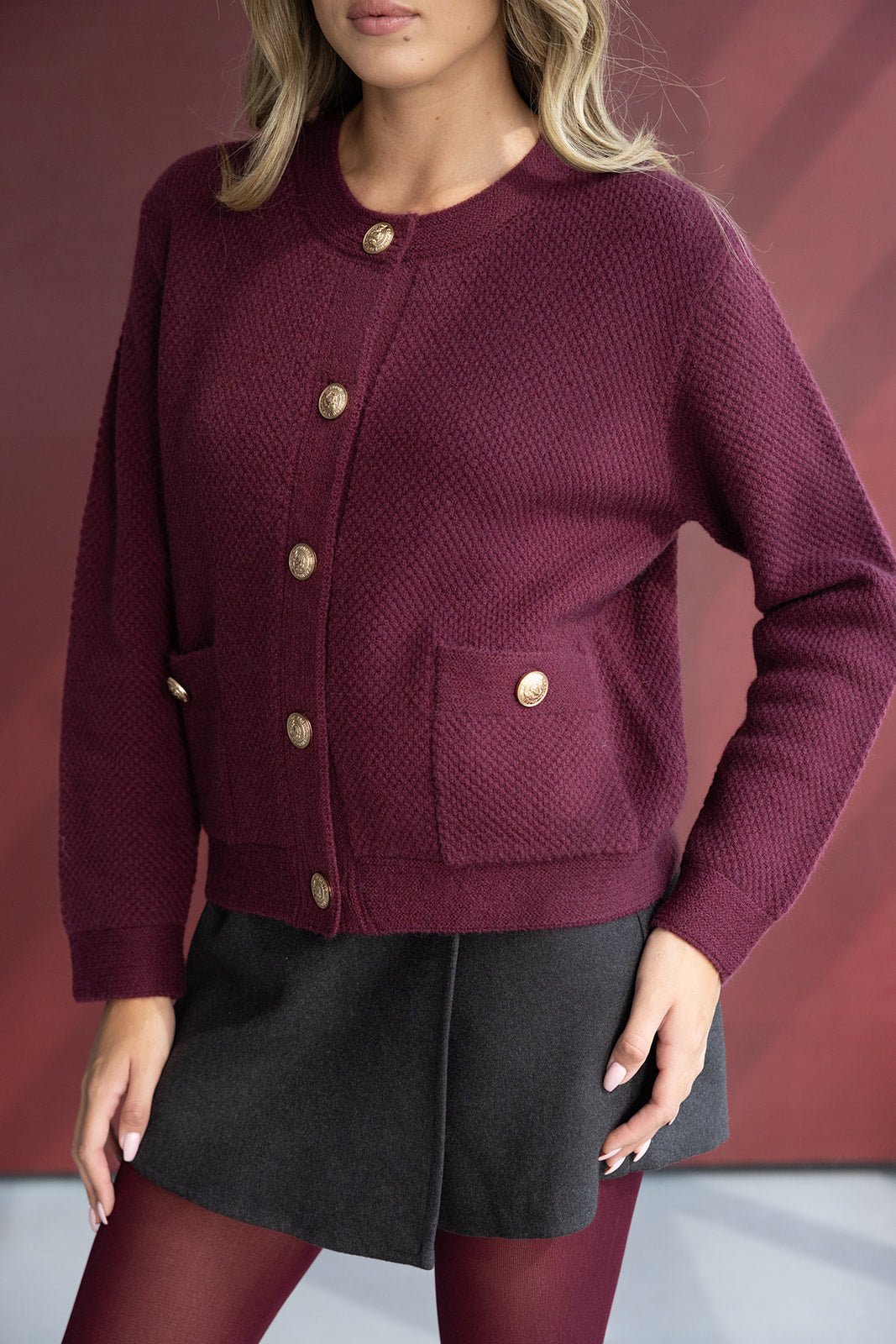 קרדיגן בורדו לנשים עם כפתורי זהב, חצאית שחורה וגרביון בורדו אופנתי