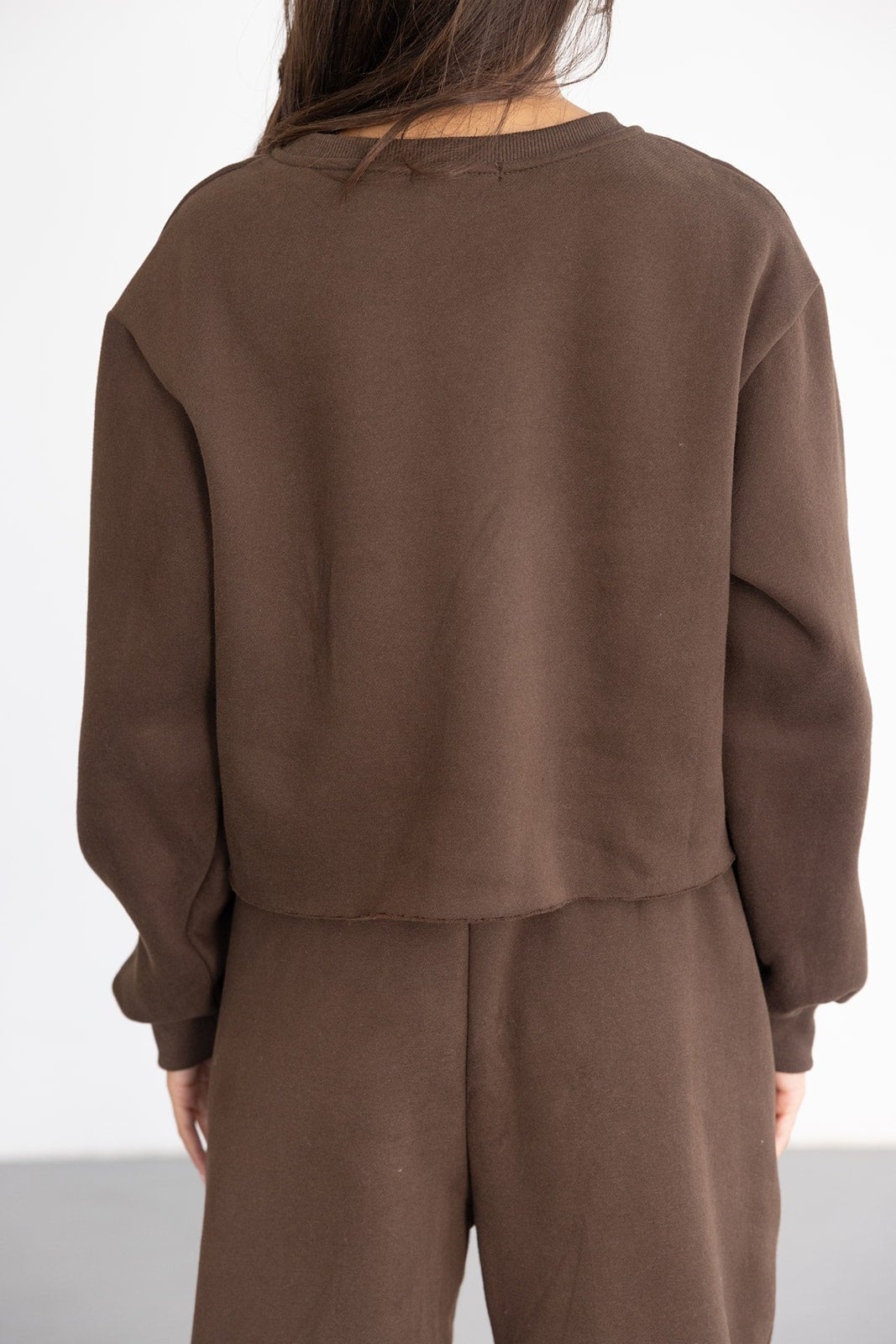 אישה לובשת סט טרנינג חום, מבט מאחור, בגדי אופנה לנשים ונערות