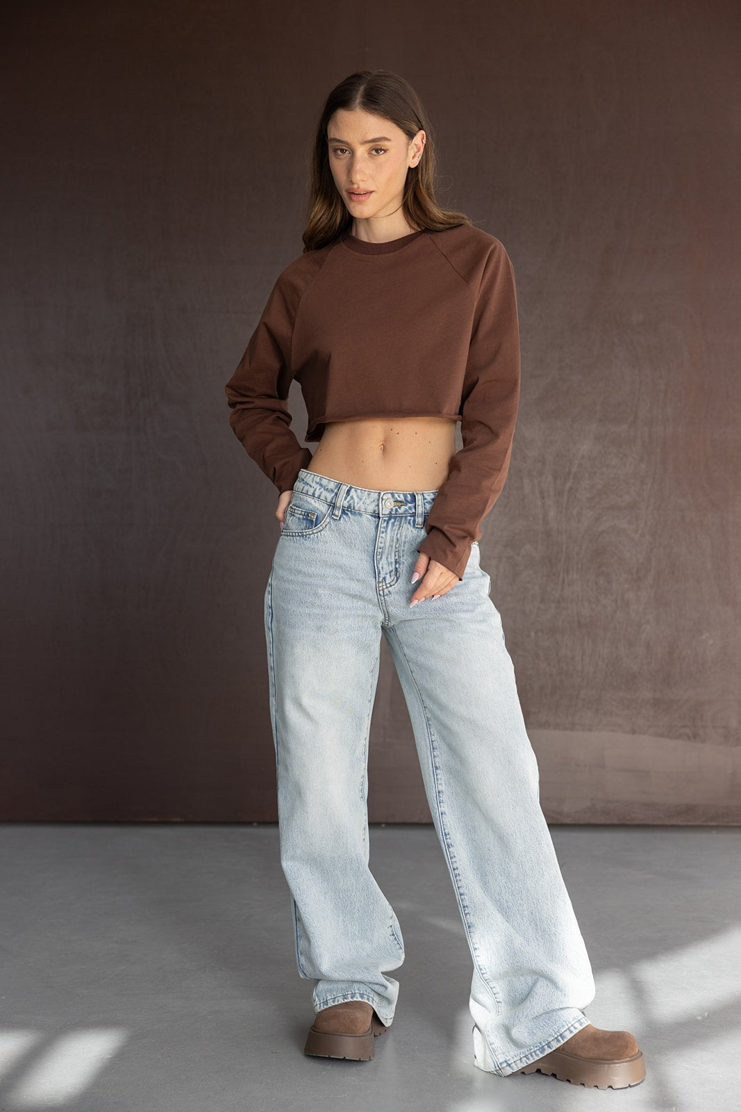 דוגמנית עם סווטשירט חום קרופ, ג'ינס בגזרה רחבה ונעלי פלטפורמה חומות, אופנת נשים טרנדי