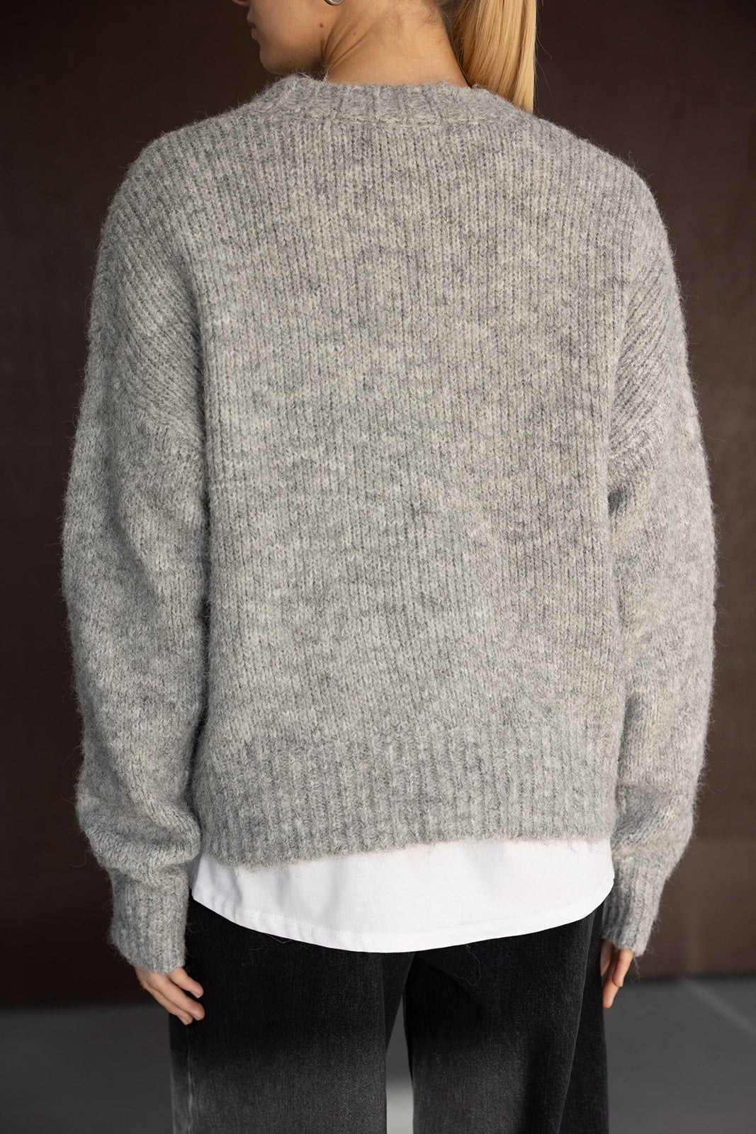 סוודר נשים אפור מרופד, בגזר ה רחבה ושרוולים ארוכים, מעל חולצה לבנה ומכנסיים שחורים