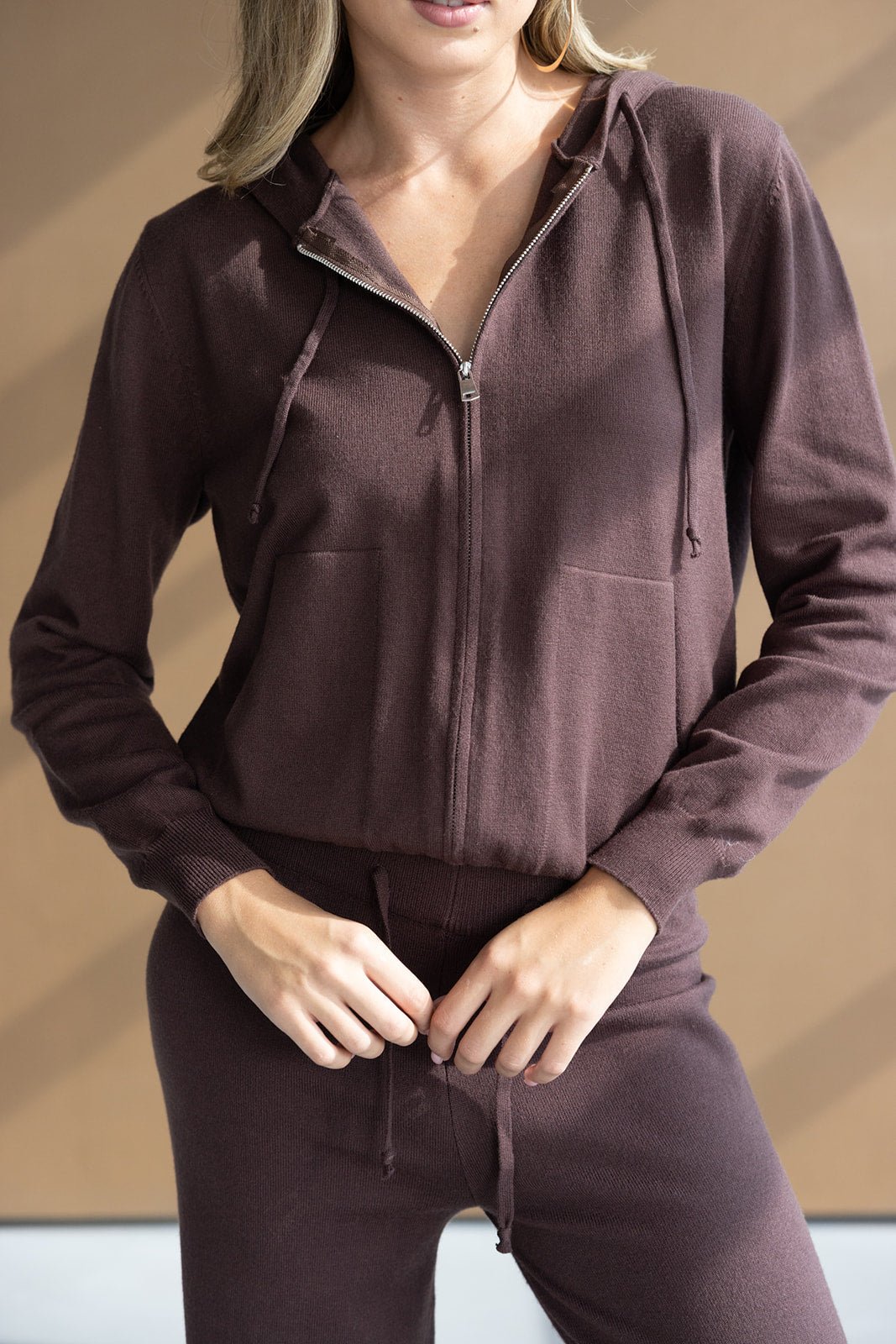 אישה לובשת סט טרנינג חום עם קפוצ׳ון ורוכסן, אופנה לנשים, בגדי נוחות צעירים