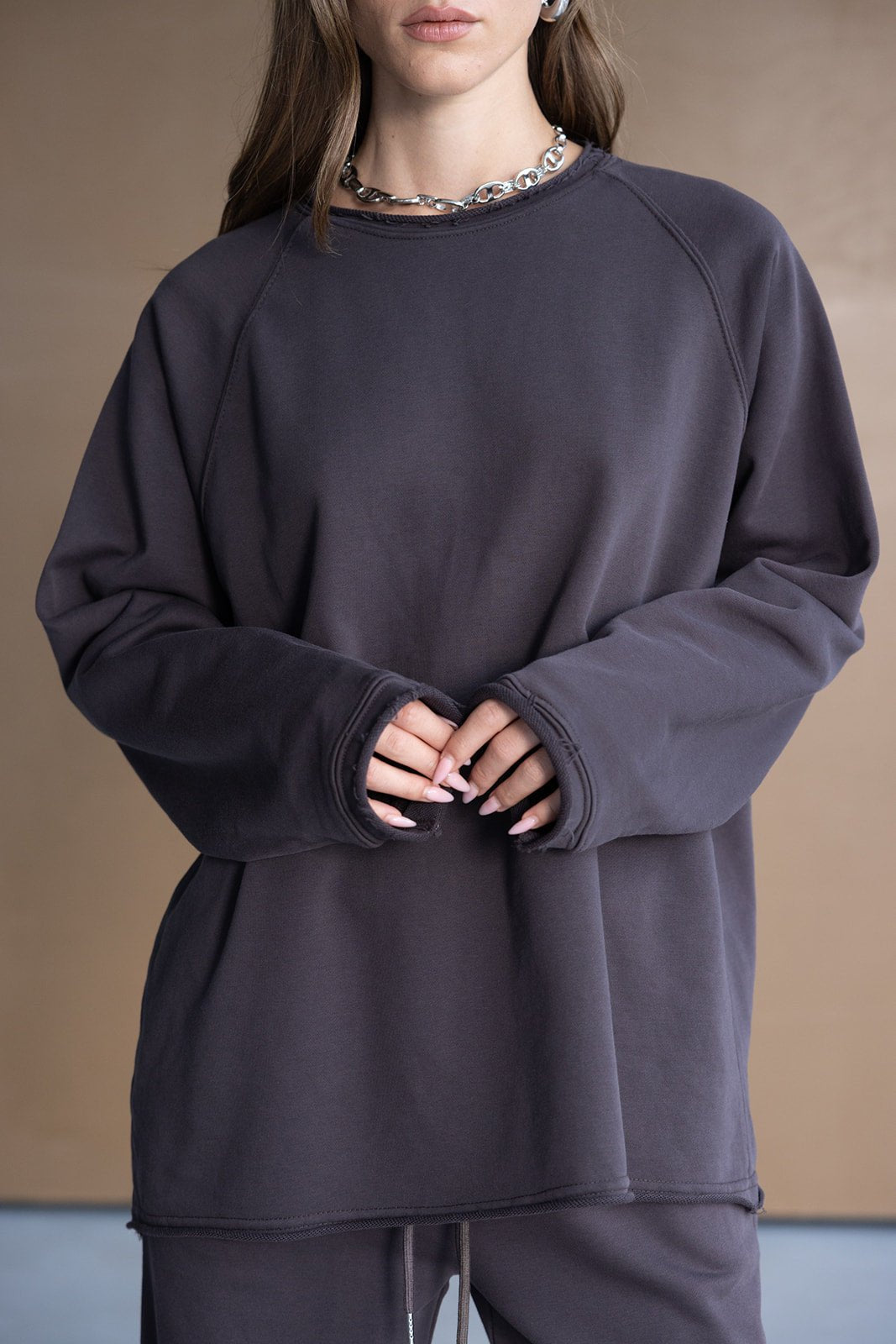 אישה לובשת סווטשירט אופנתי שחור עם שרוולים ארוכים, בגדי נוחות טרנדים לנשים