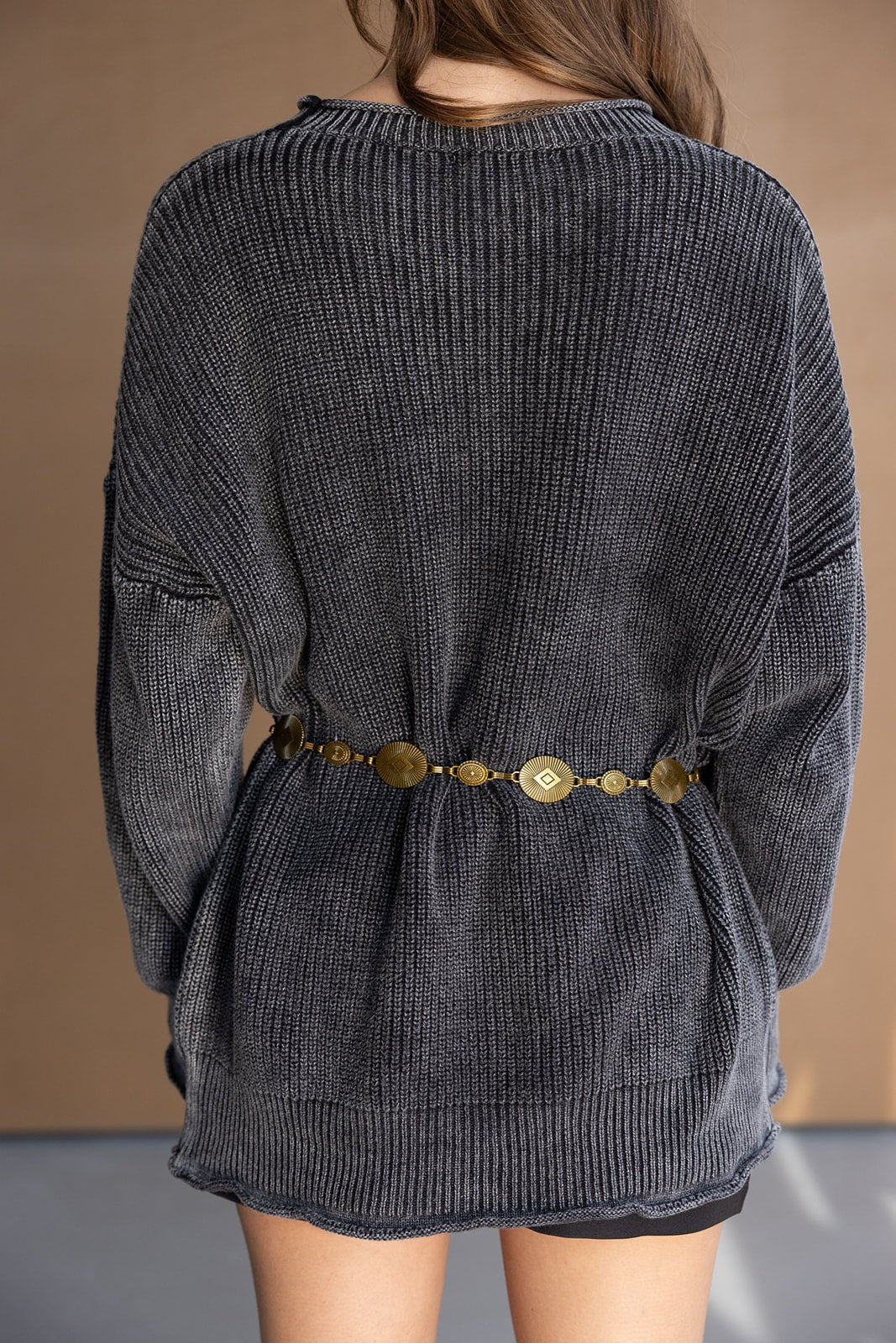 סוודר סרוג לנשים בצבע אפור כהה עם חגורת מתכת זהב טרנדית, צילום מאחור