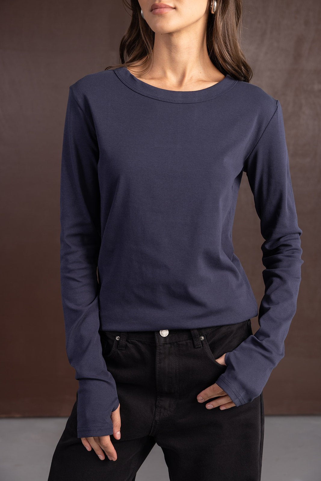 אישה לובשת חולצת שרוולים ארוכים כותנה בצבע כחול כהה ומכנסיים שחורים, אופנת נשים צעירה