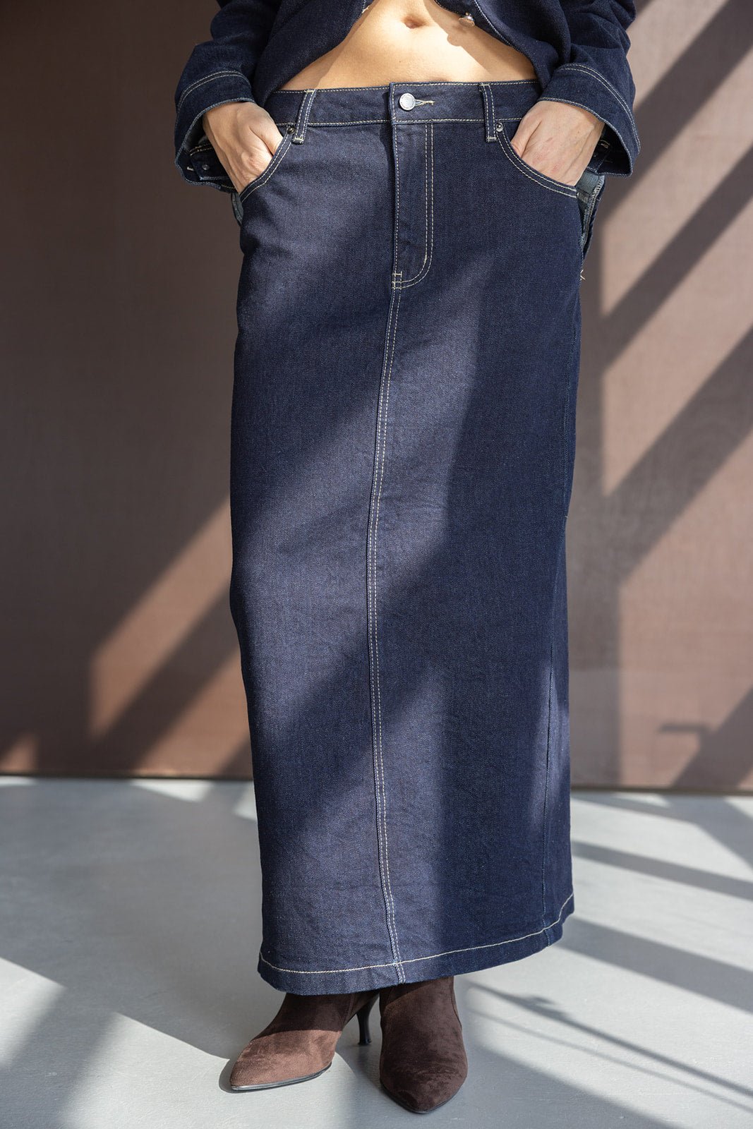 חצאית ג'ינס מקסי כחולה לאישה עם תפרים בולטים ונעלי עקב חומות, אופנת נשים