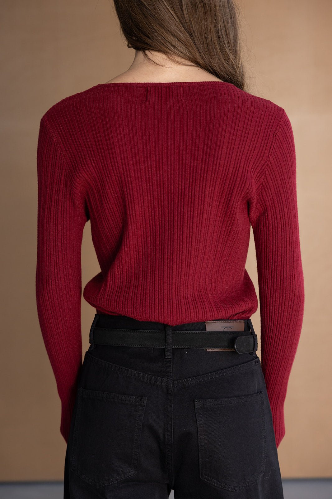 סוודר אדום סרוג לנשים עם שרוולים ארוכים, משולב עם מכנסי ג'ינס שחורים, מראה אופנתי צעיר