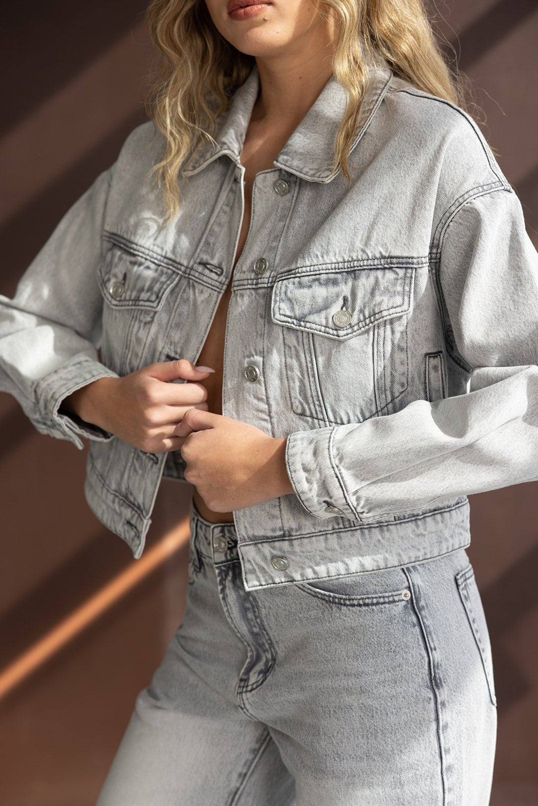 אישה לובשת ג'קט ג'ינס אפור אופנתי ותואם עם מכנסי ג'ינס לנשים, טרנד אופנה לנערות